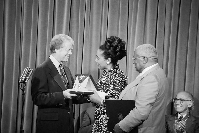 President Jimmy Carter presents the Medal of Freedom here to Coretta Scott King, accepting posthumously for her slain husband, Martin Luther King Jr, for his civil rights work. At right is King's father Martin Luther King, Sr.
