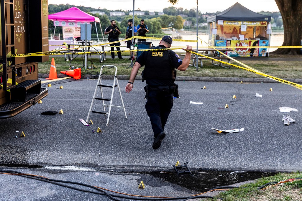 Police officer investigating a crash scene at a festival.