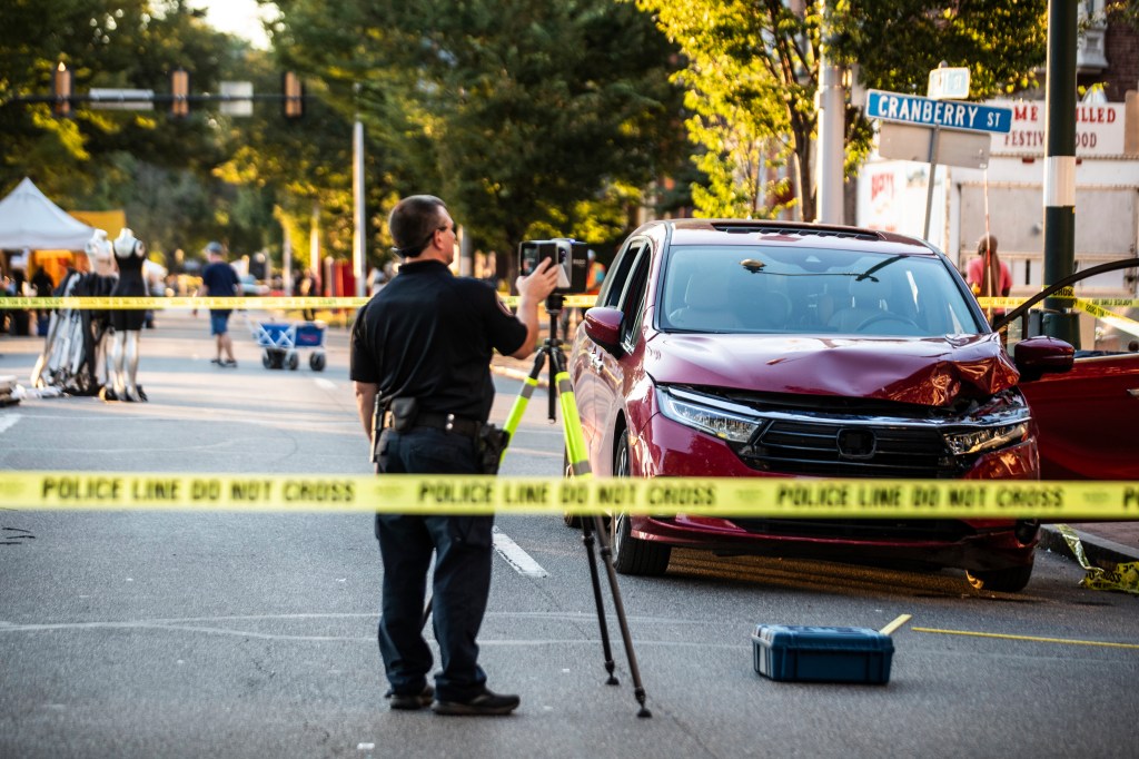 Police officer surveying a car accident scene.
