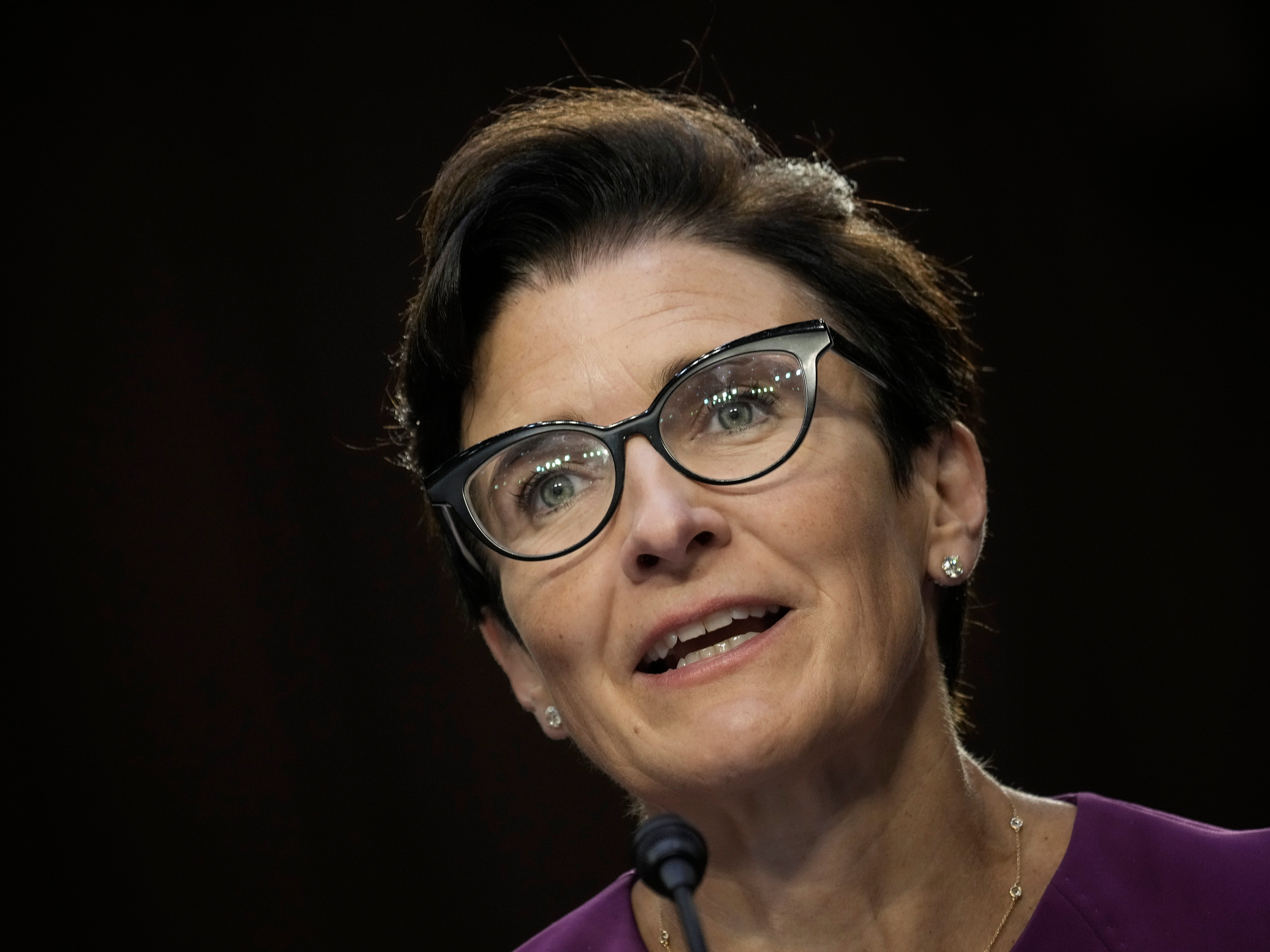 A woman with glasses speaks