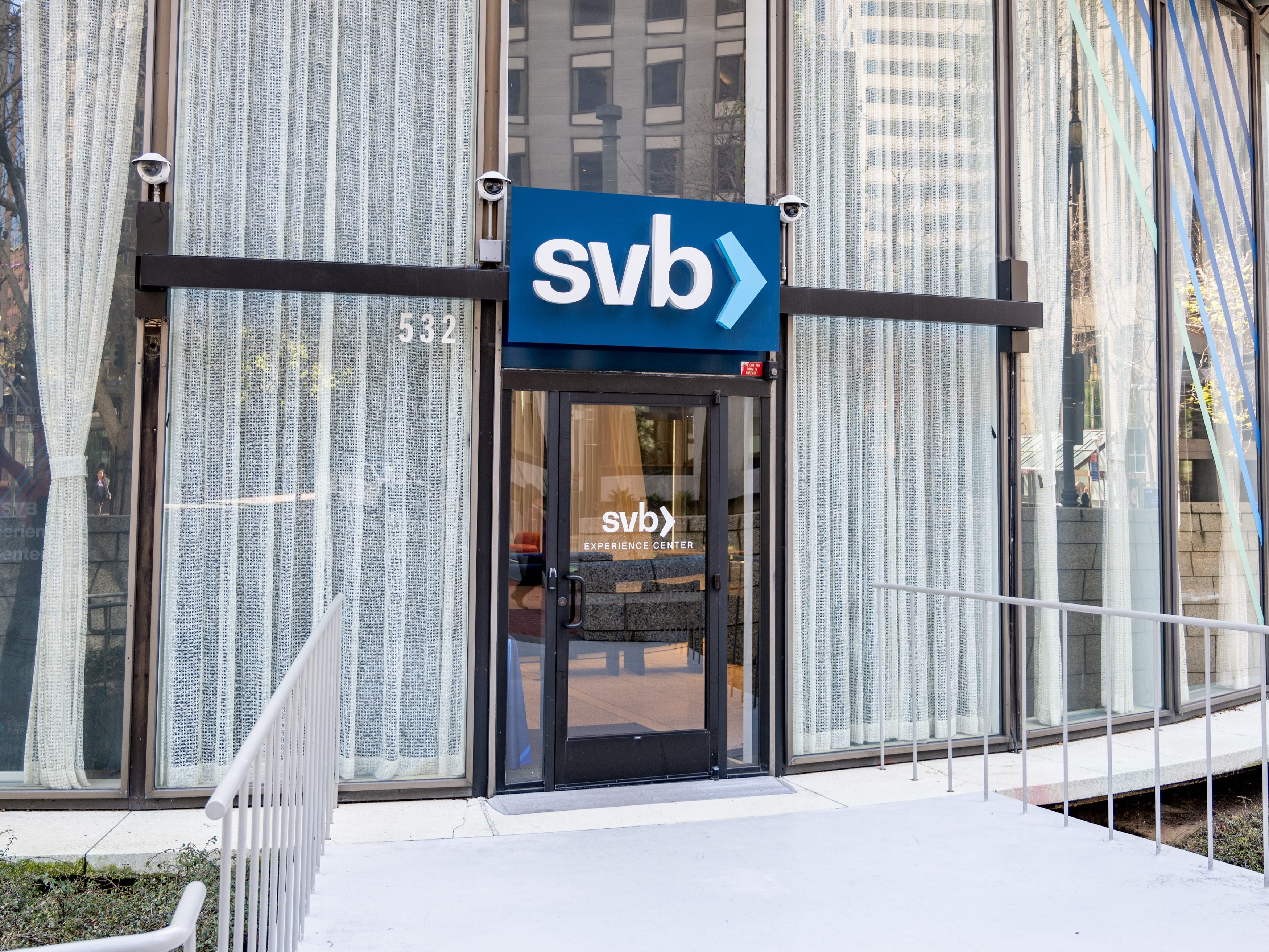 Exterior view of a curved glass building with prominent SVB (Silicon Valley Bank) sign near the entrance, Financial District, San Francisco, California, March 18, 2025.