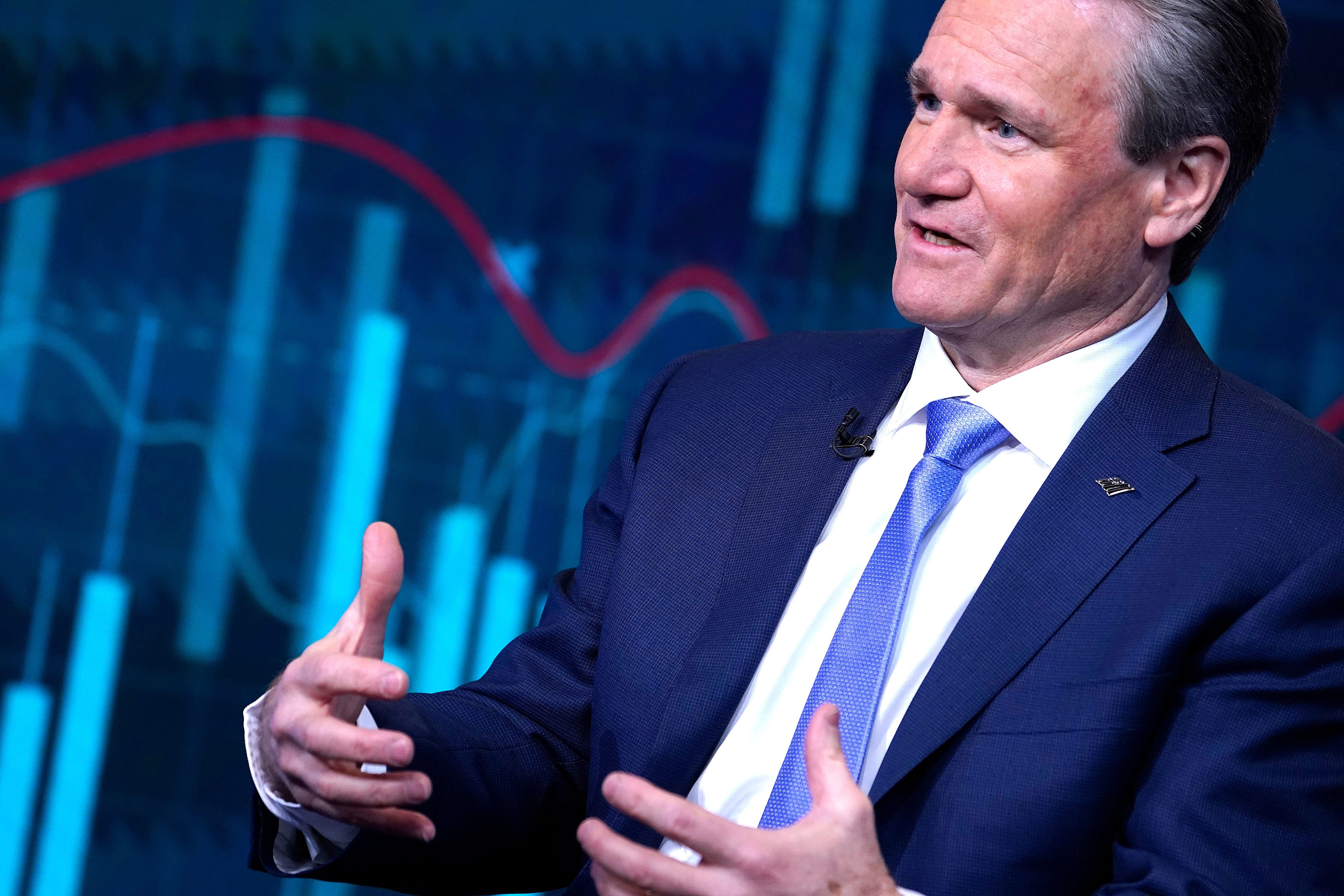 Brian Moynihan gesturing on a TV set wearing a suit and blue tie.
