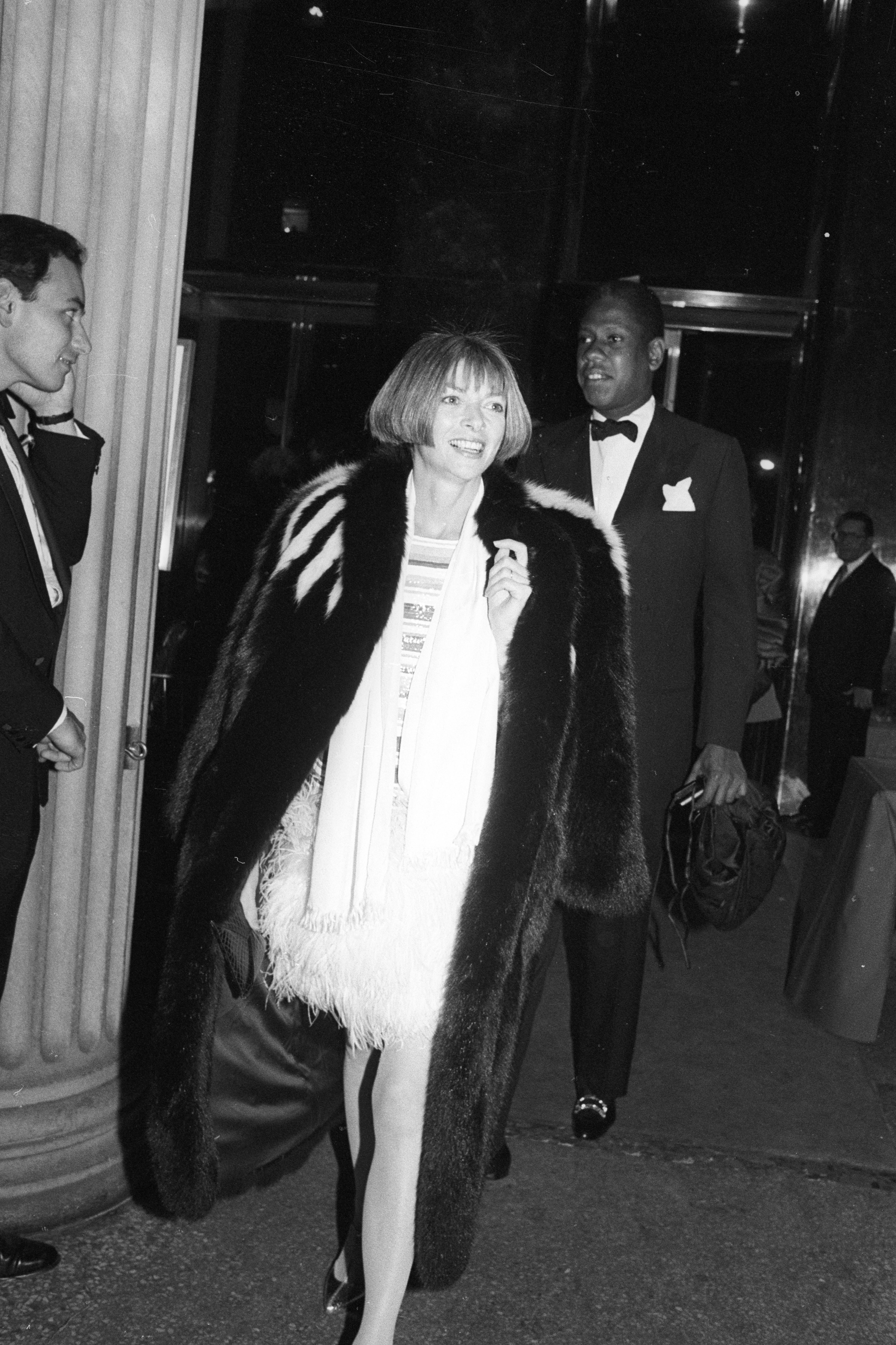 Anna Wintour pictured outside a party, wearing a fur coat.