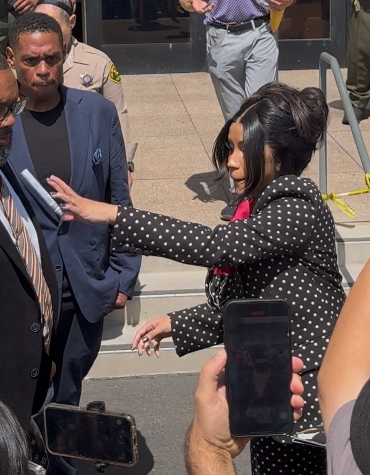 Cardi B throws a marker in a black suit. 