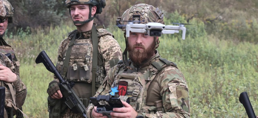 Infantrymen of the 13th Khartiia Operational Brigade of Ukraine's National Guard look at an FPV as part of a training session in the Kharkiv region, Ukraine, on August 28, 2025.