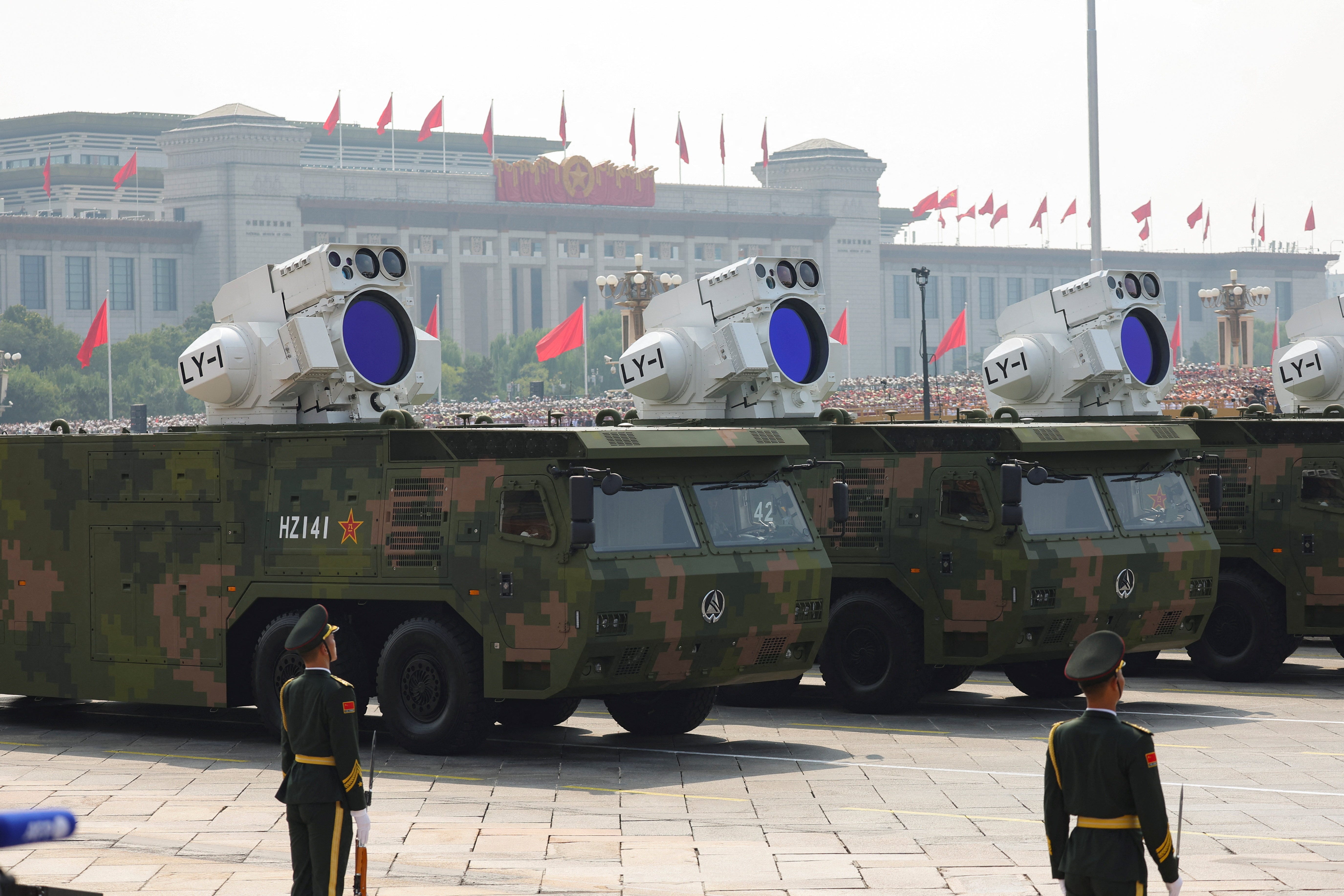 A member of the People's Liberation Army stands as the maritime operations group displays laser weapons during a military parade.