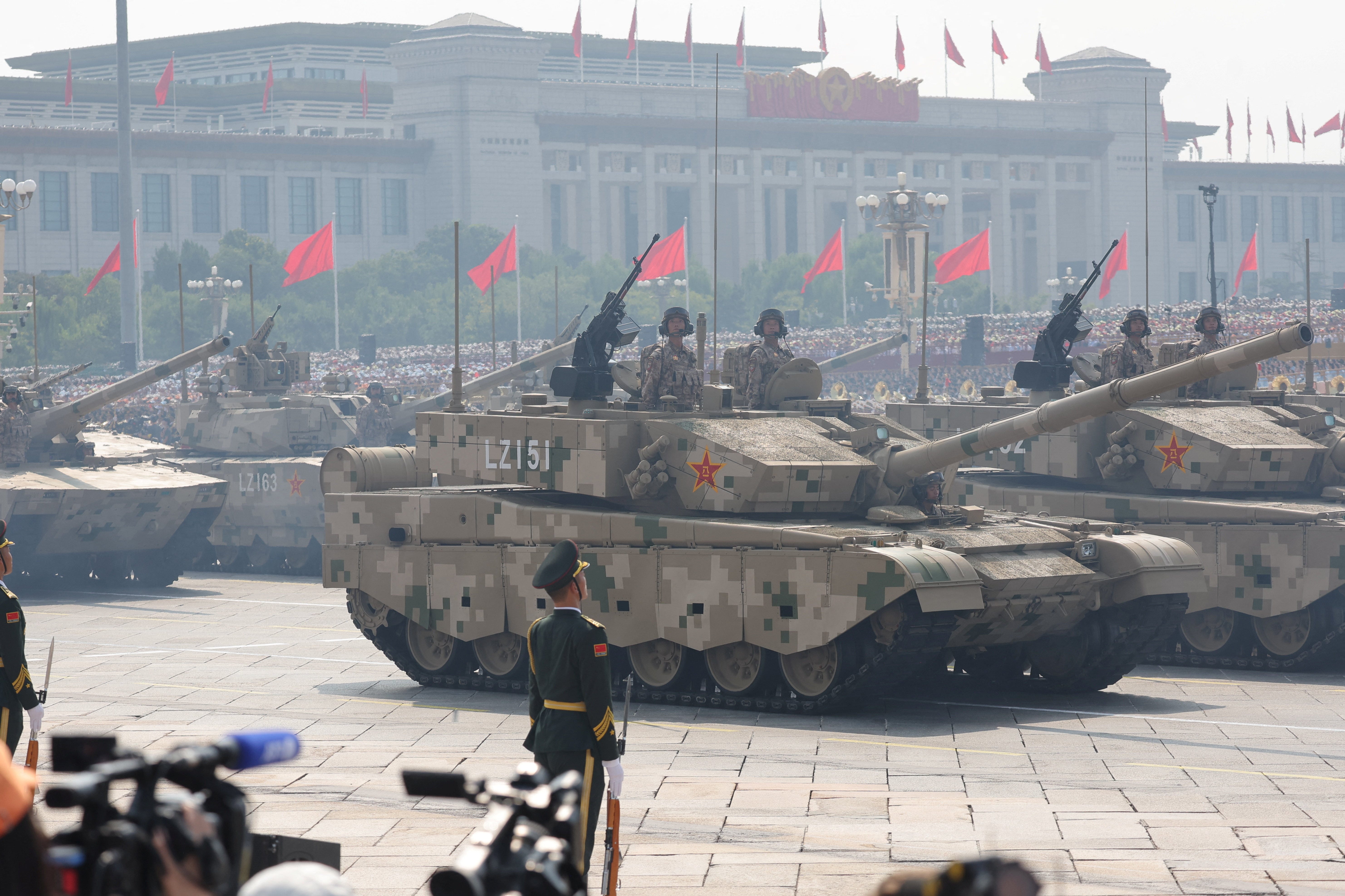 Members of the People's Liberation Army stand as the land operations group displays tanks.