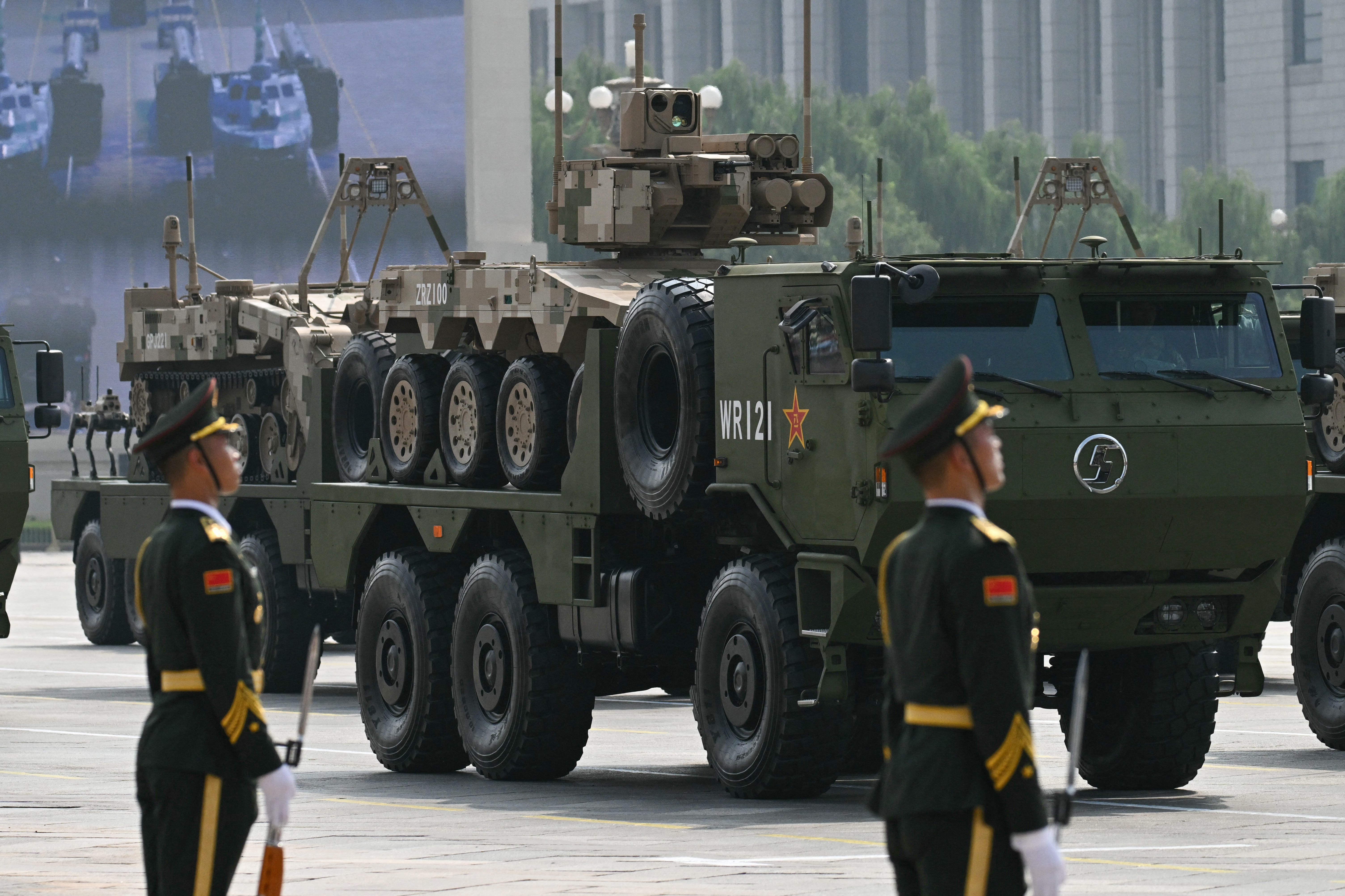 A Chinese uncrewed ground vehicle is seen during a military parade while being carried by a transport truck.