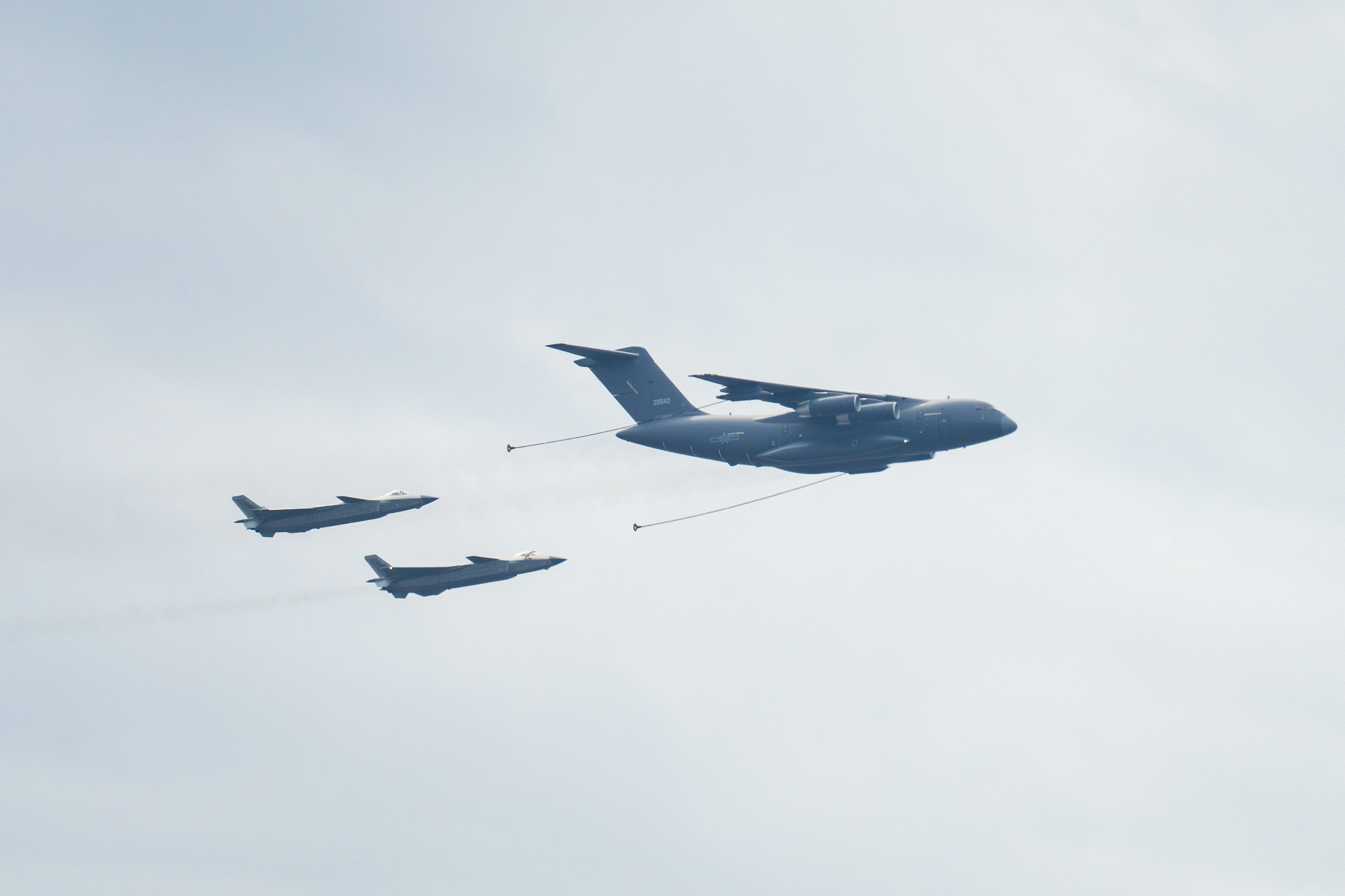 The J-20 stealth fighters and Yunyou-20, or YY-20, aerial refueling aircraft, fly in the sky during a rehearsal.
