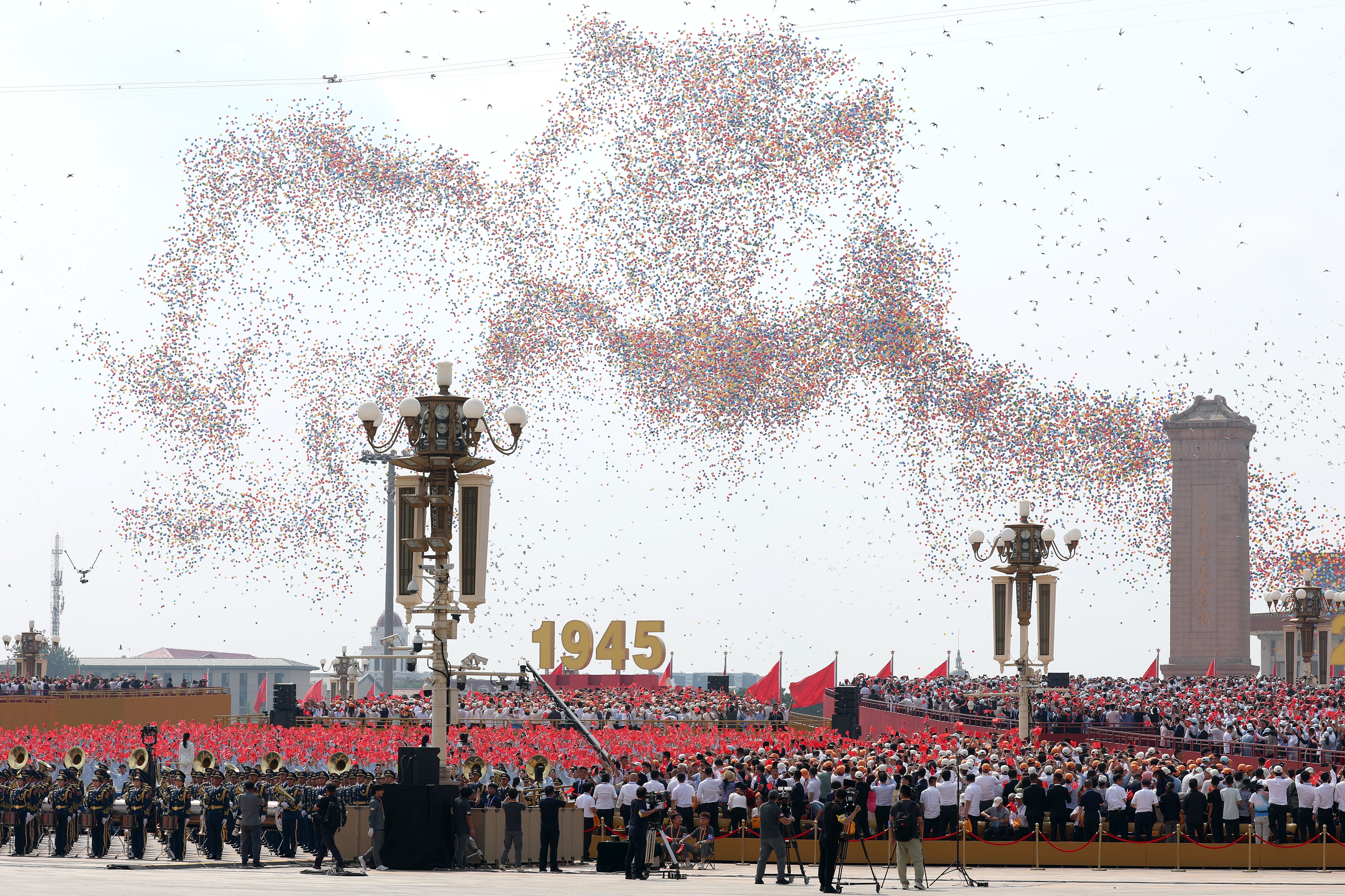 Balloons and doves are released into the air during the victory day parade.