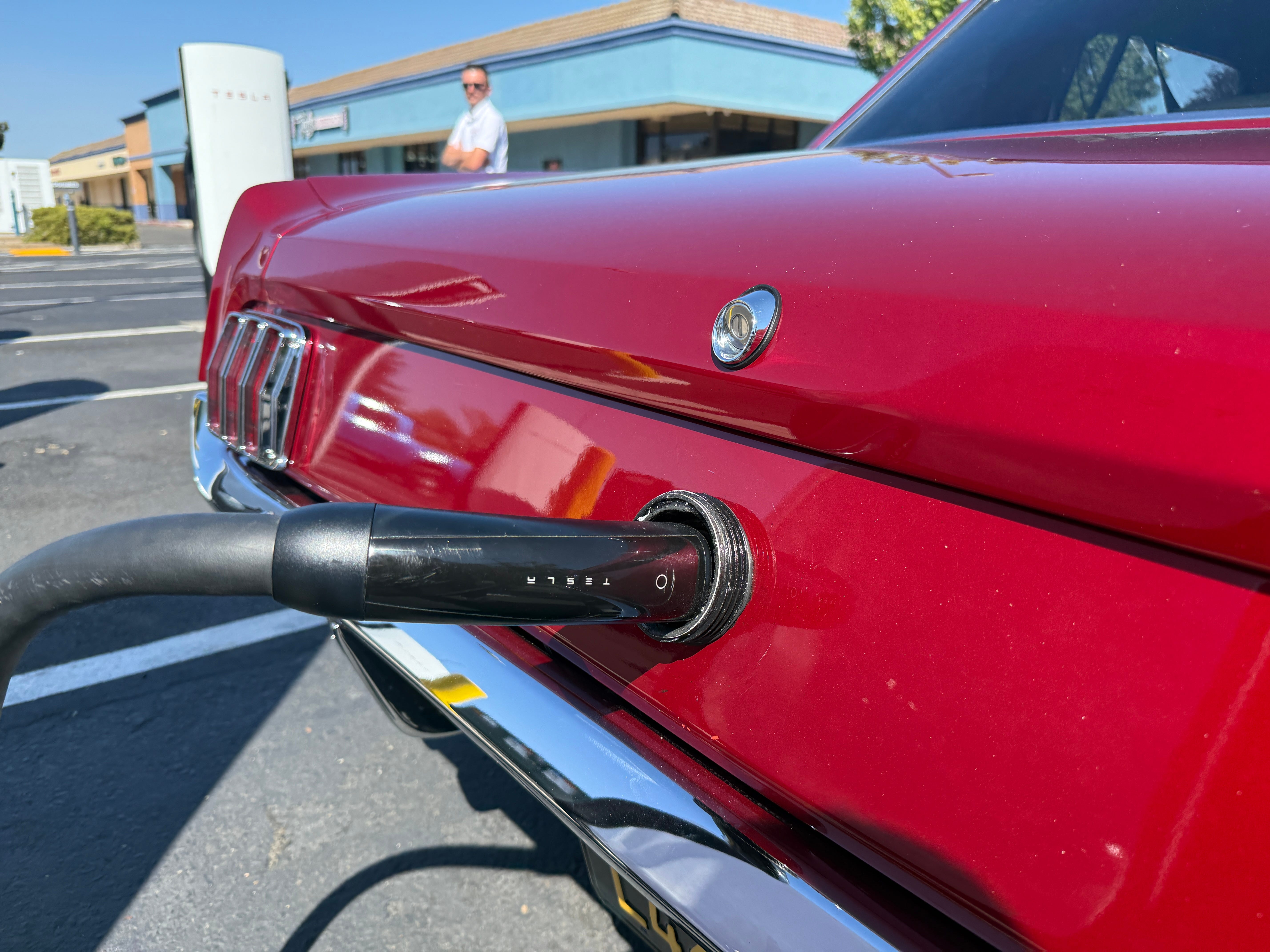 A Tesla charging port inside of a '66 Mustang