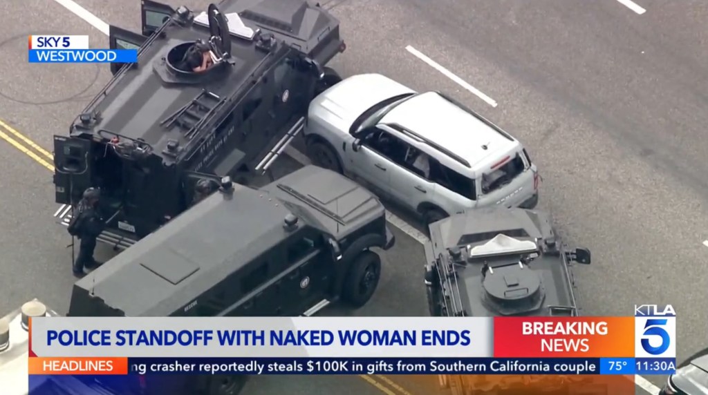 Armored vehicles block the path of the woman's car.