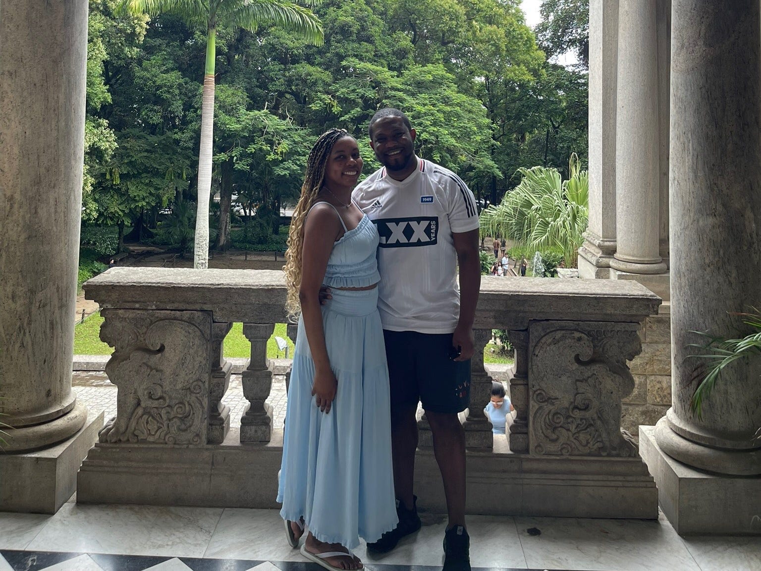The author and her boyfriend standing between two columns in front of a courtyard.