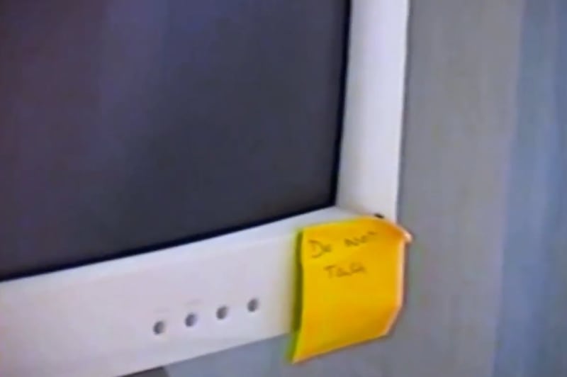 Yellow note reading "do not touch" on computer monitor.