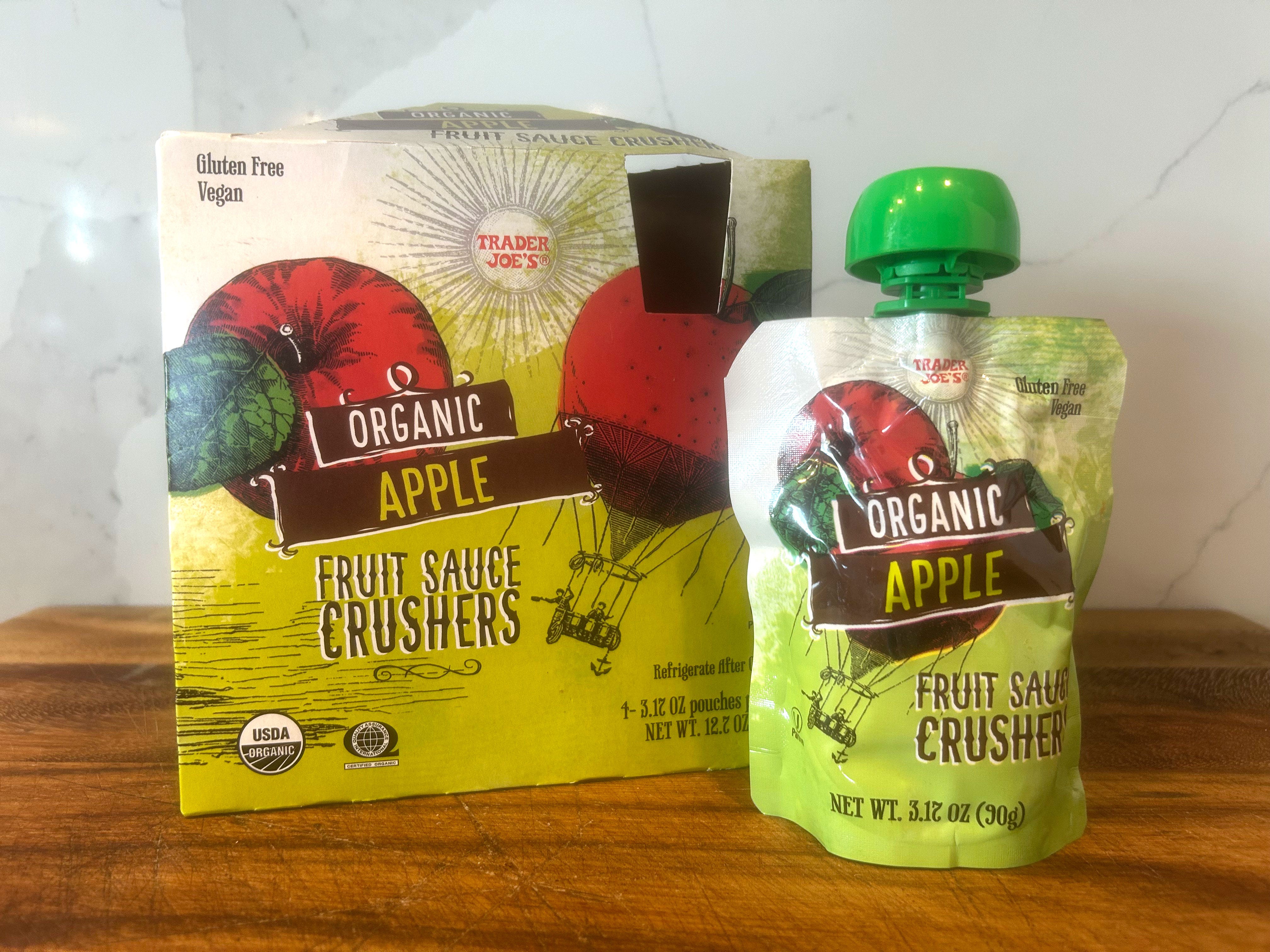 A box of Trader Joe's organic apple fruit sauce crushers and a pouch of the product next to it.