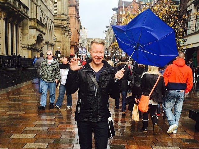 Andre Neveling holding an umbrella on a street in London.