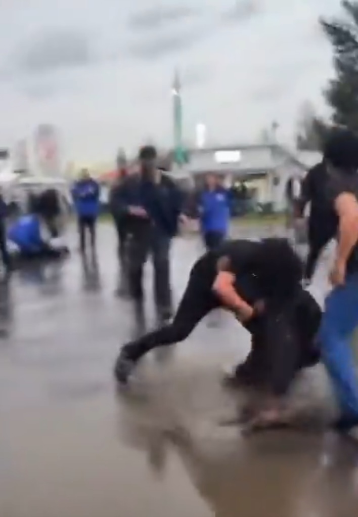 A fight breaking out in a crowd of people.