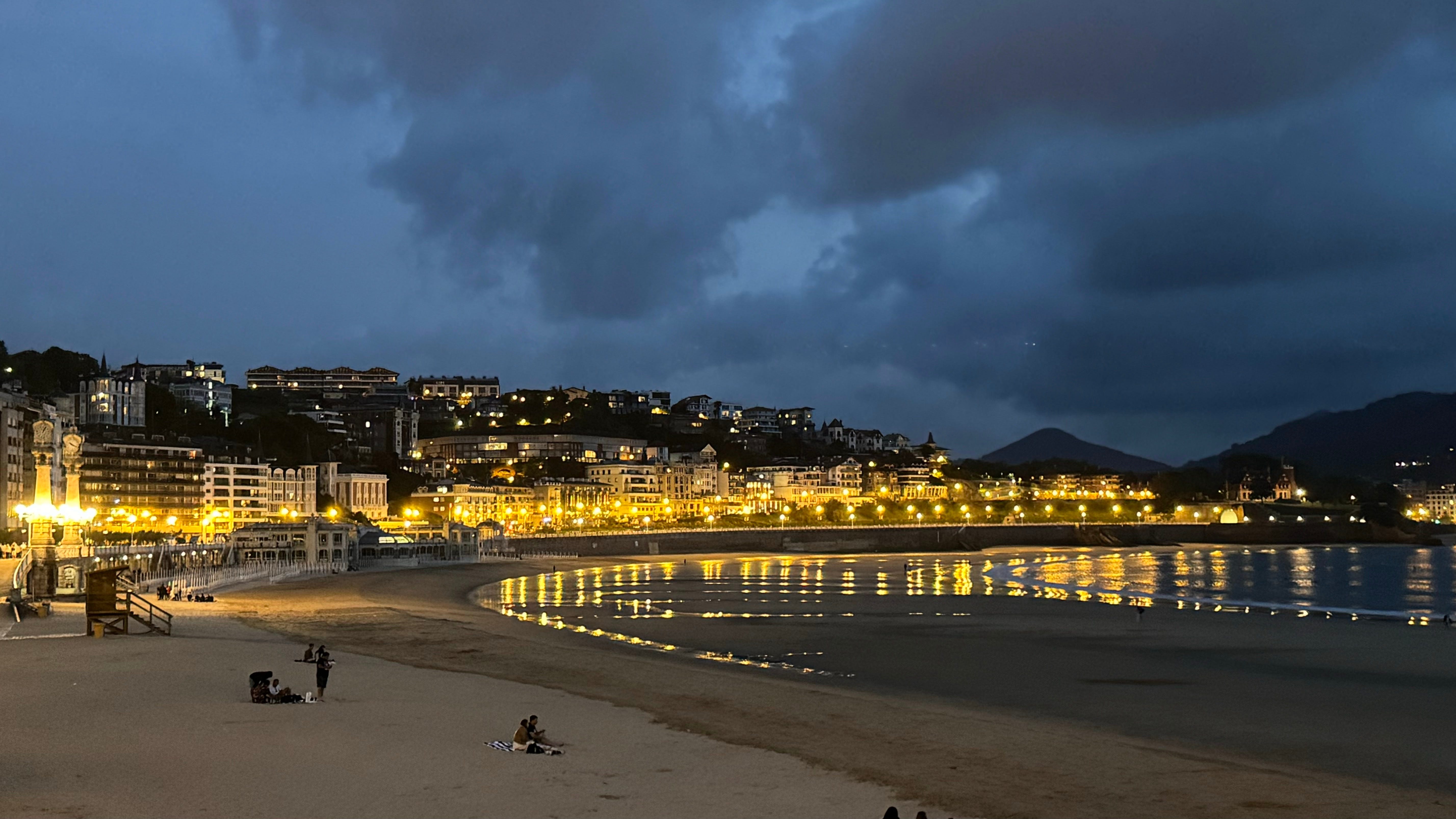 Lit-up buildings along beachy coast at night