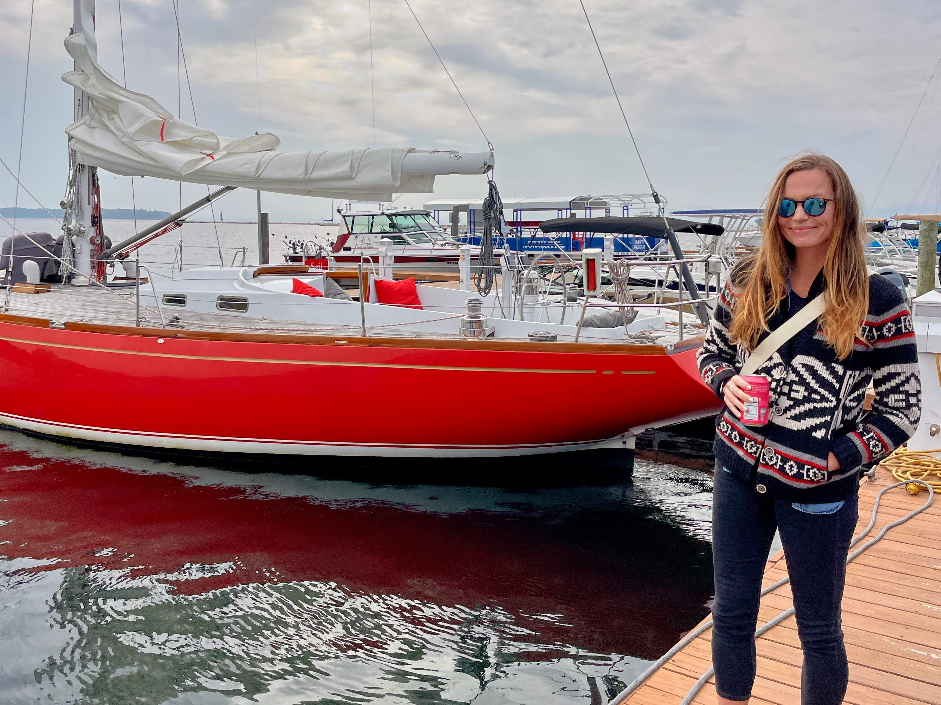 Emily standing on a dock next to a red boat in Burlington, Virginia.