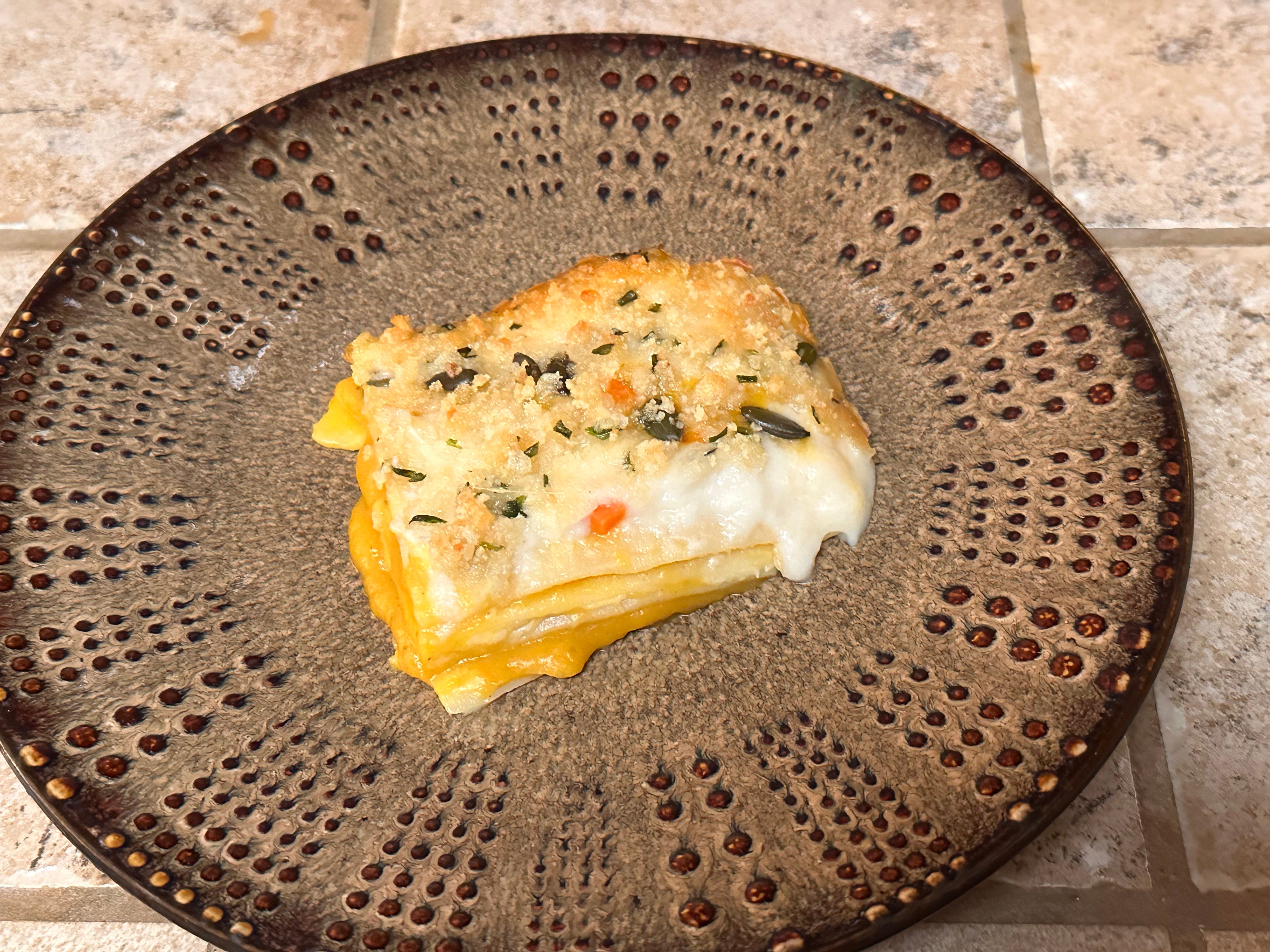 a slice of cheesy, white and yellow lasagna on plate