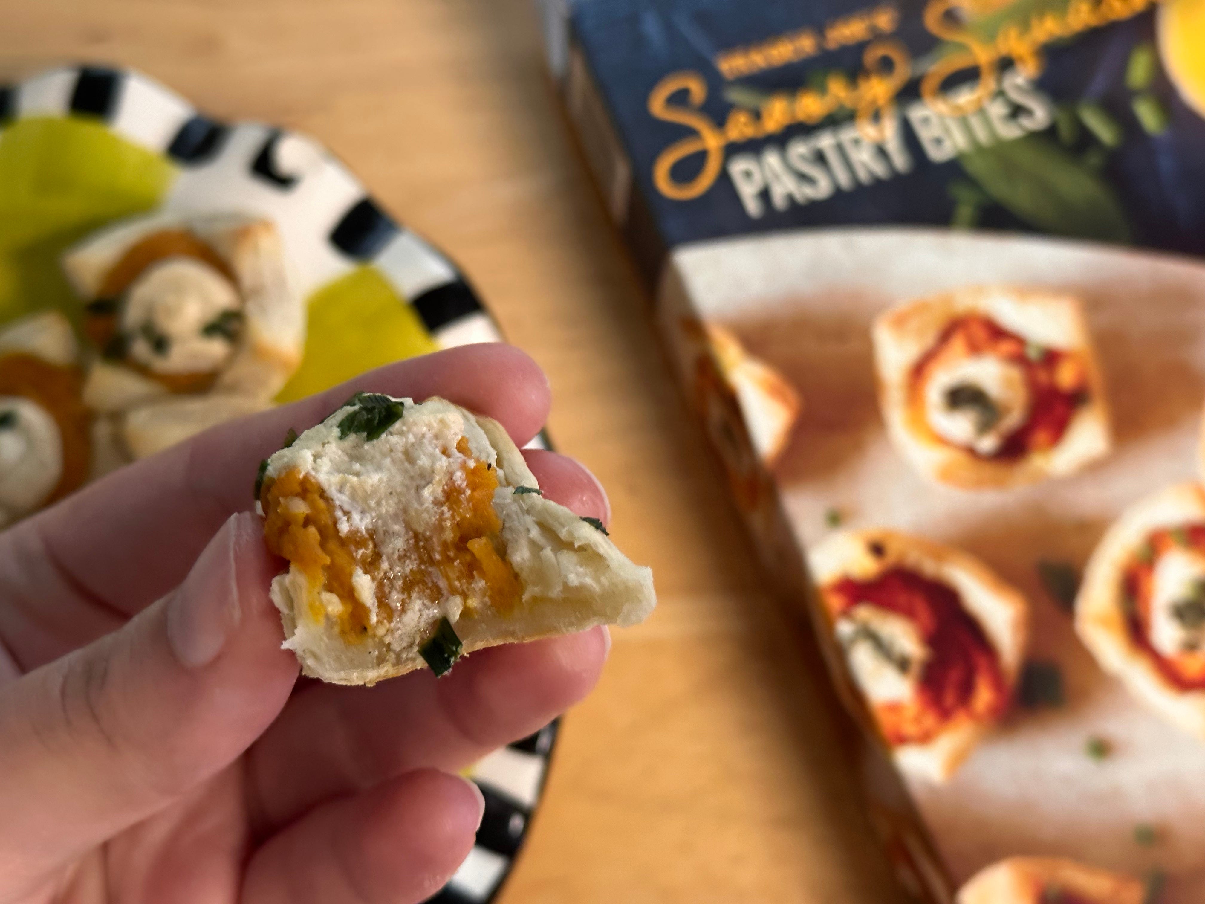 Half-eaten pastry bite showing pumpkin and cheese