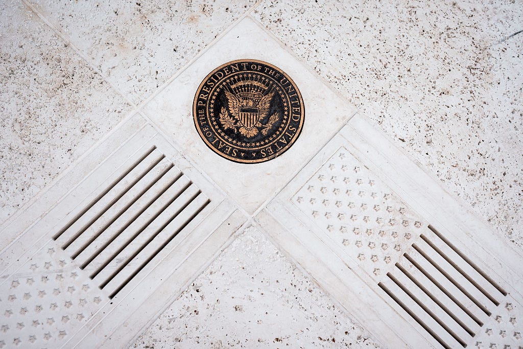 The presidential seal and American flags on tiles in the Rose Garden.