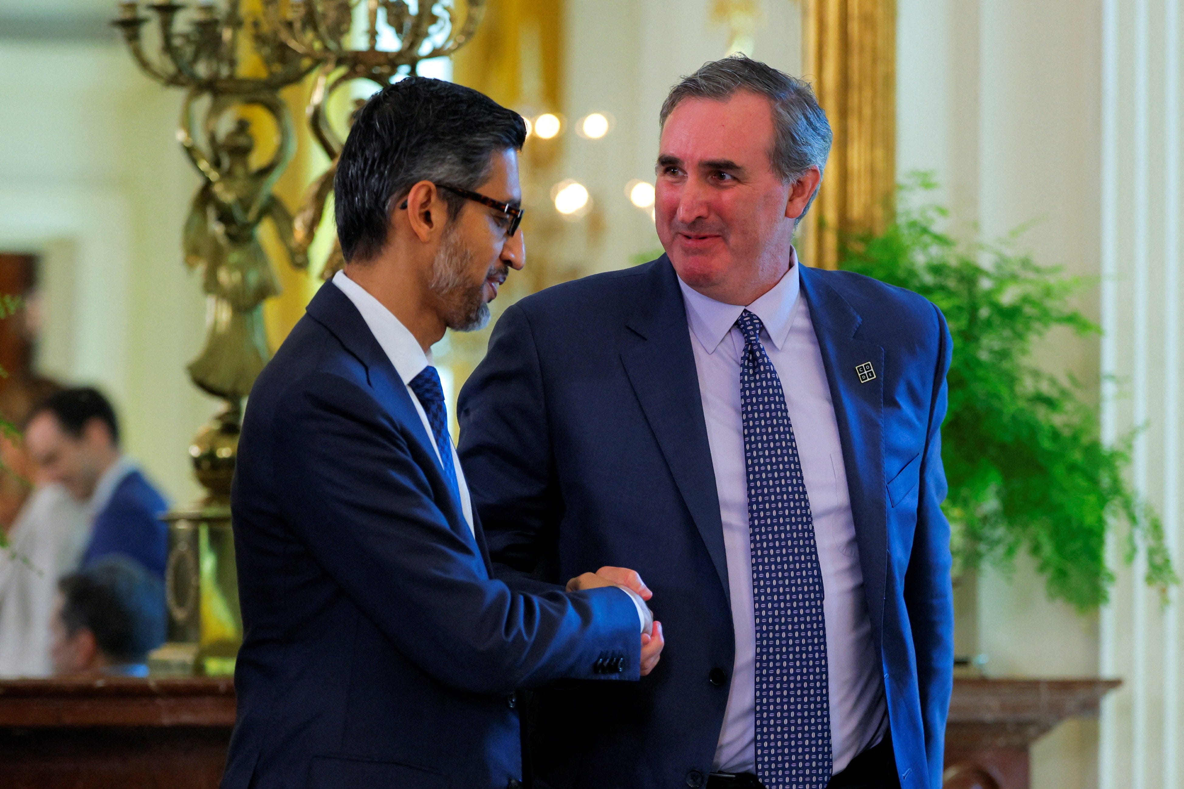 Google CEO Sundar Pichai shakes hands with Cameron Wilson, President of Code.org, on the day of a meeting of the White House Task Force on Artificial Intelligence (AI) Education in the East Room at the White House in Washington, D.C., U.S., September 4, 2025.