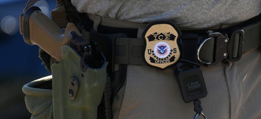  An Immigration and Customs Enforcement officer's badge and weapon are seen as ICE conducts a vehicle checkpoint on Georgia Ave. on Aug. 30, 2025 in Washington, D.C.
