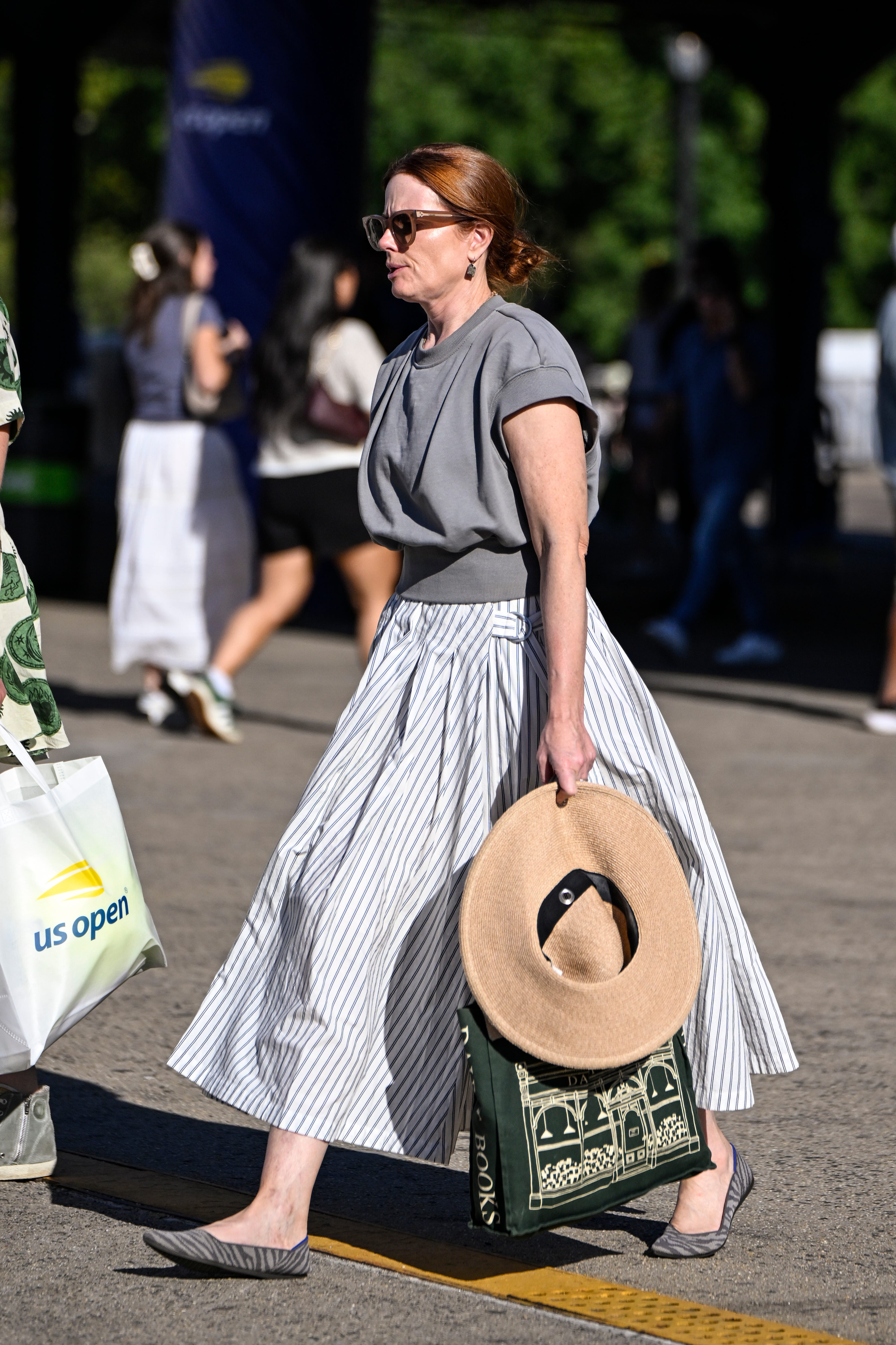 A woman in a gray shirt and long skirt.