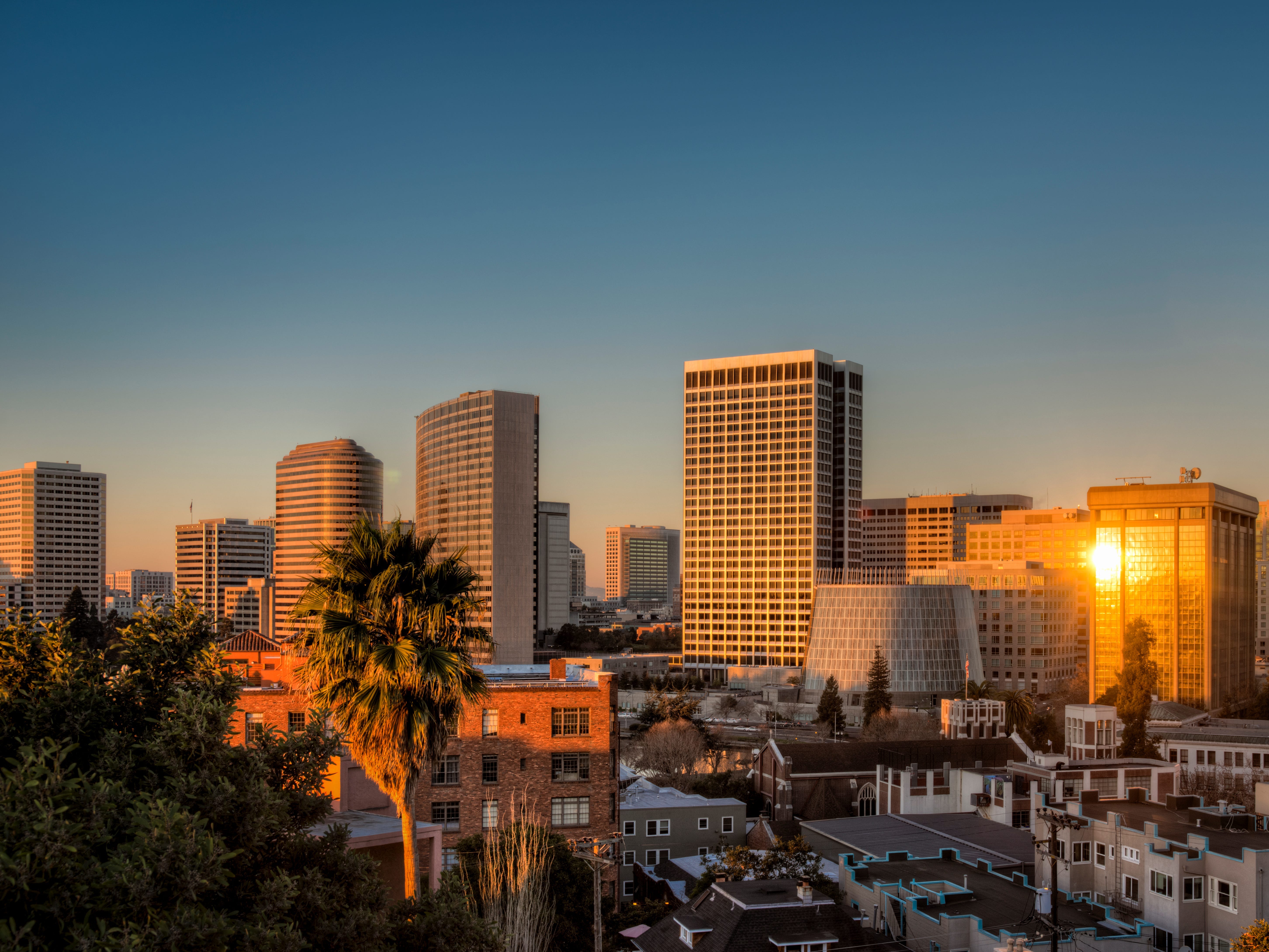 The sun rising and reflecting on buildings in downtown Oakland, California.
