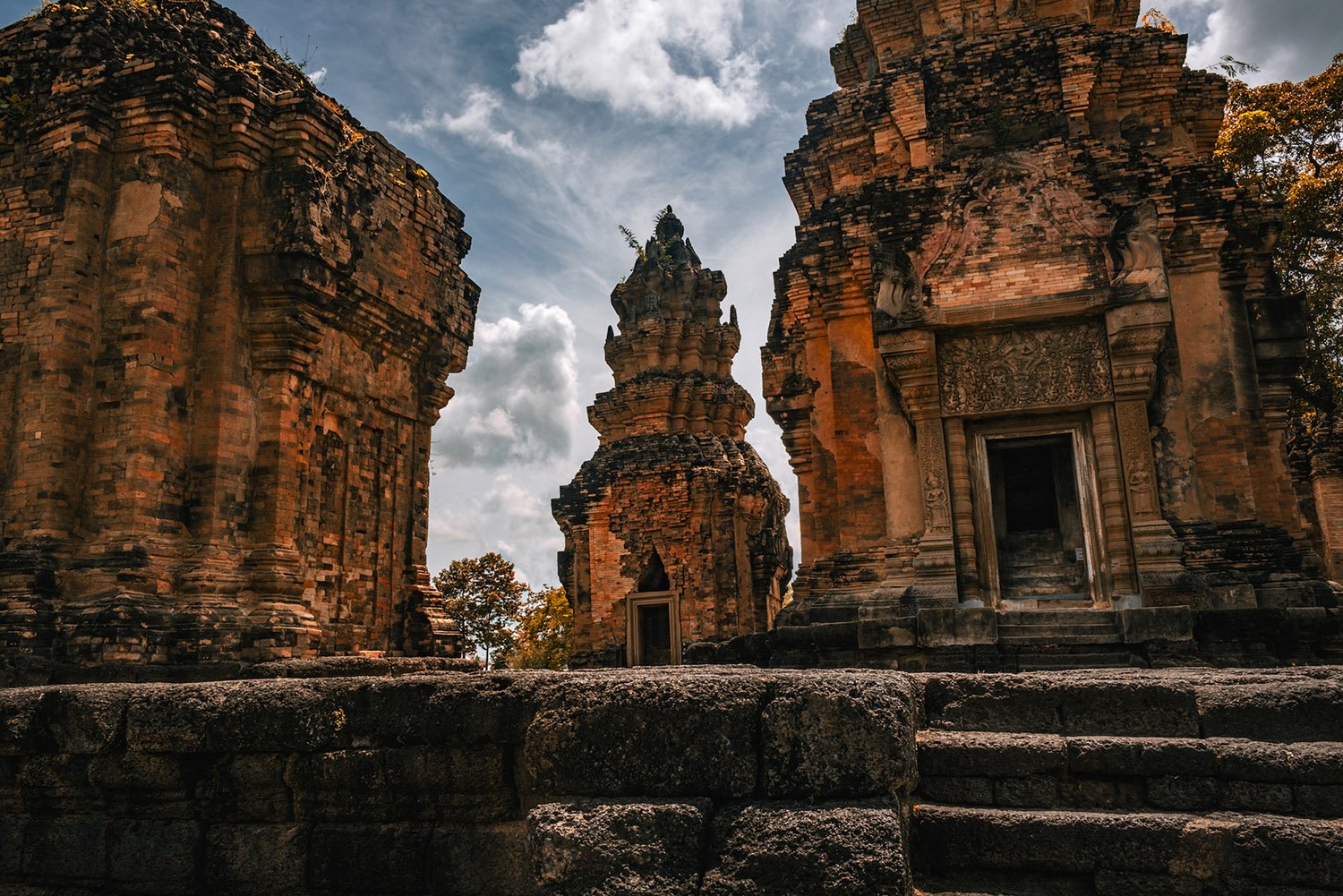 Three ornate but decaying structures at a temple.