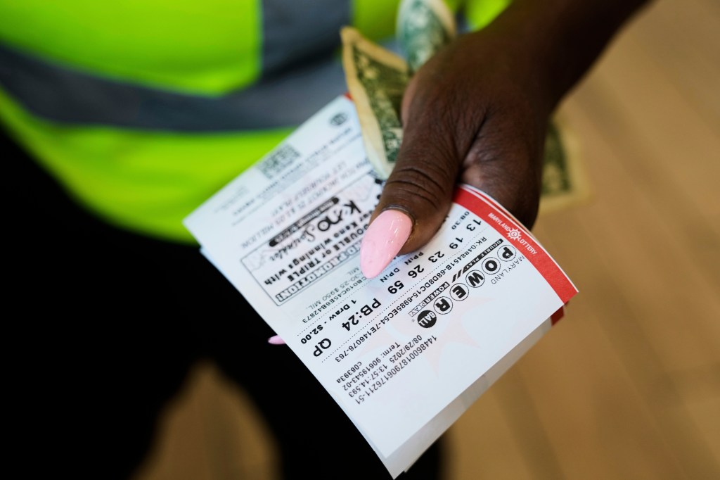 Person holding Powerball lottery tickets.