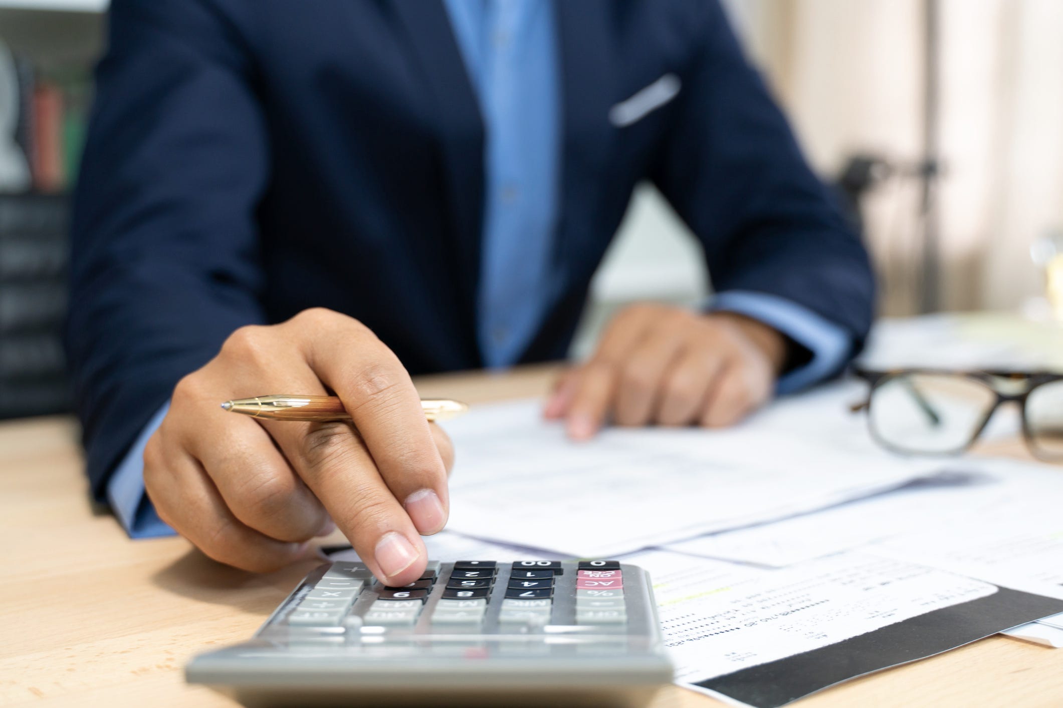 Man types into a calculator at a bank