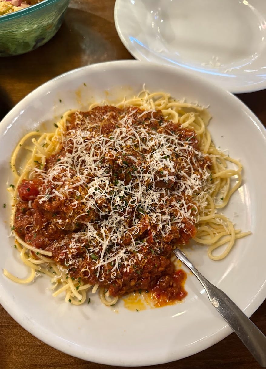 Olive Garden never-ending pasta spaghetti with spicy meat sauce and a meatball and sausage