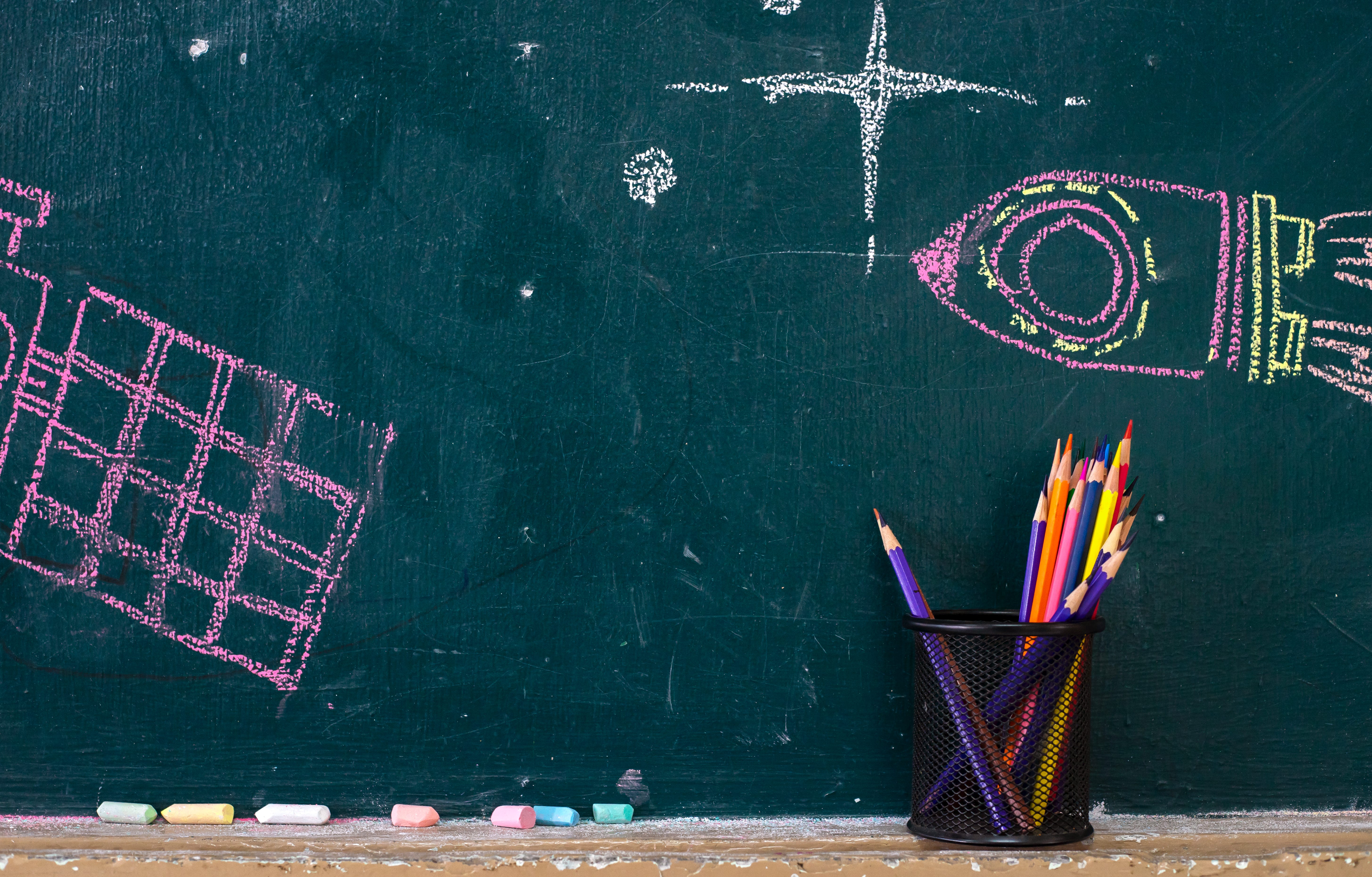 Back to school supplies. Books and blackboard on wooden background