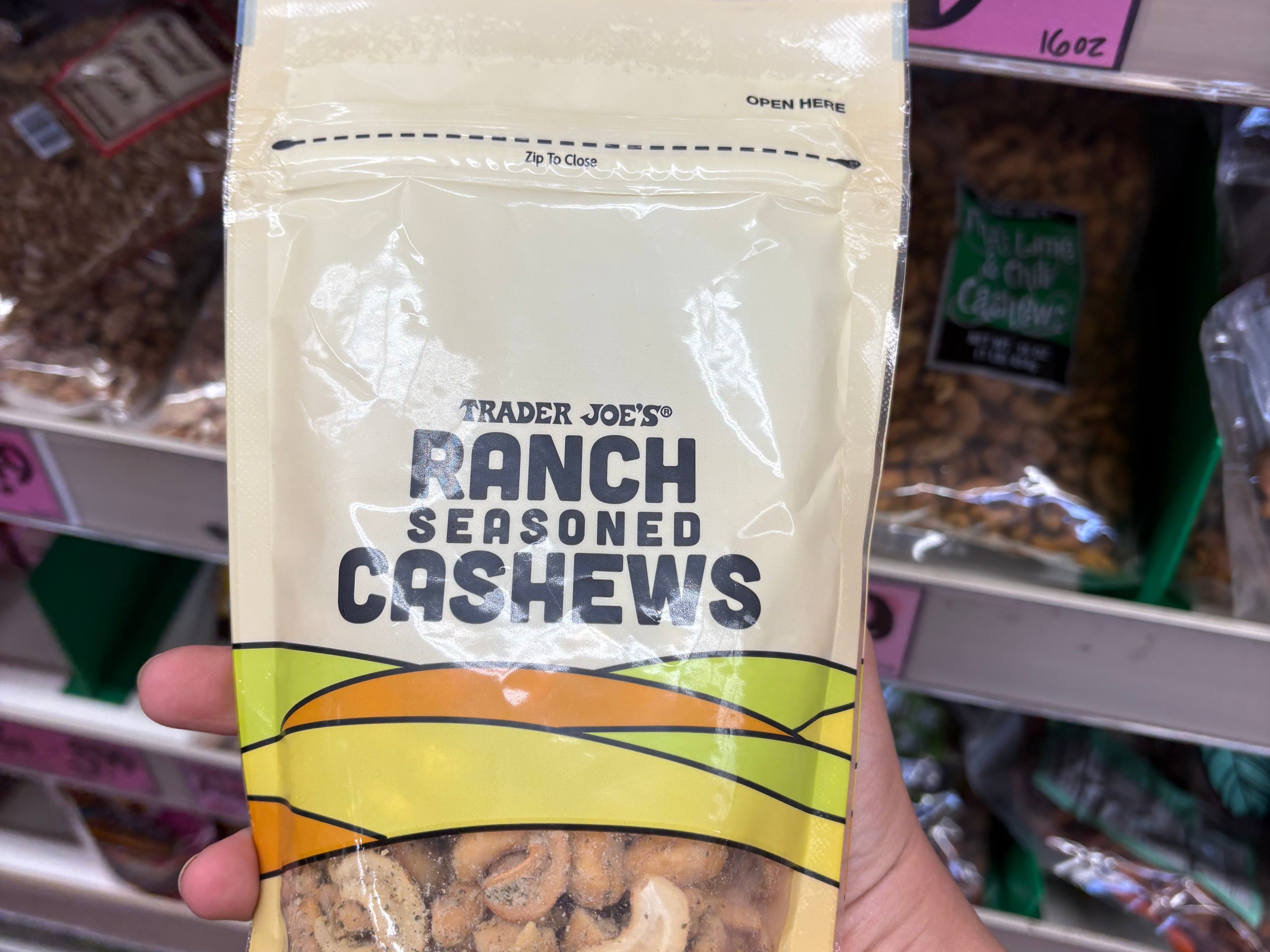 The author holding a bag of Trader Joe's ranch seasoned cashews.
