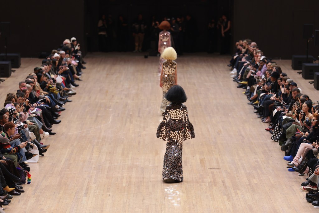 Models in sequined dresses walking a runway.