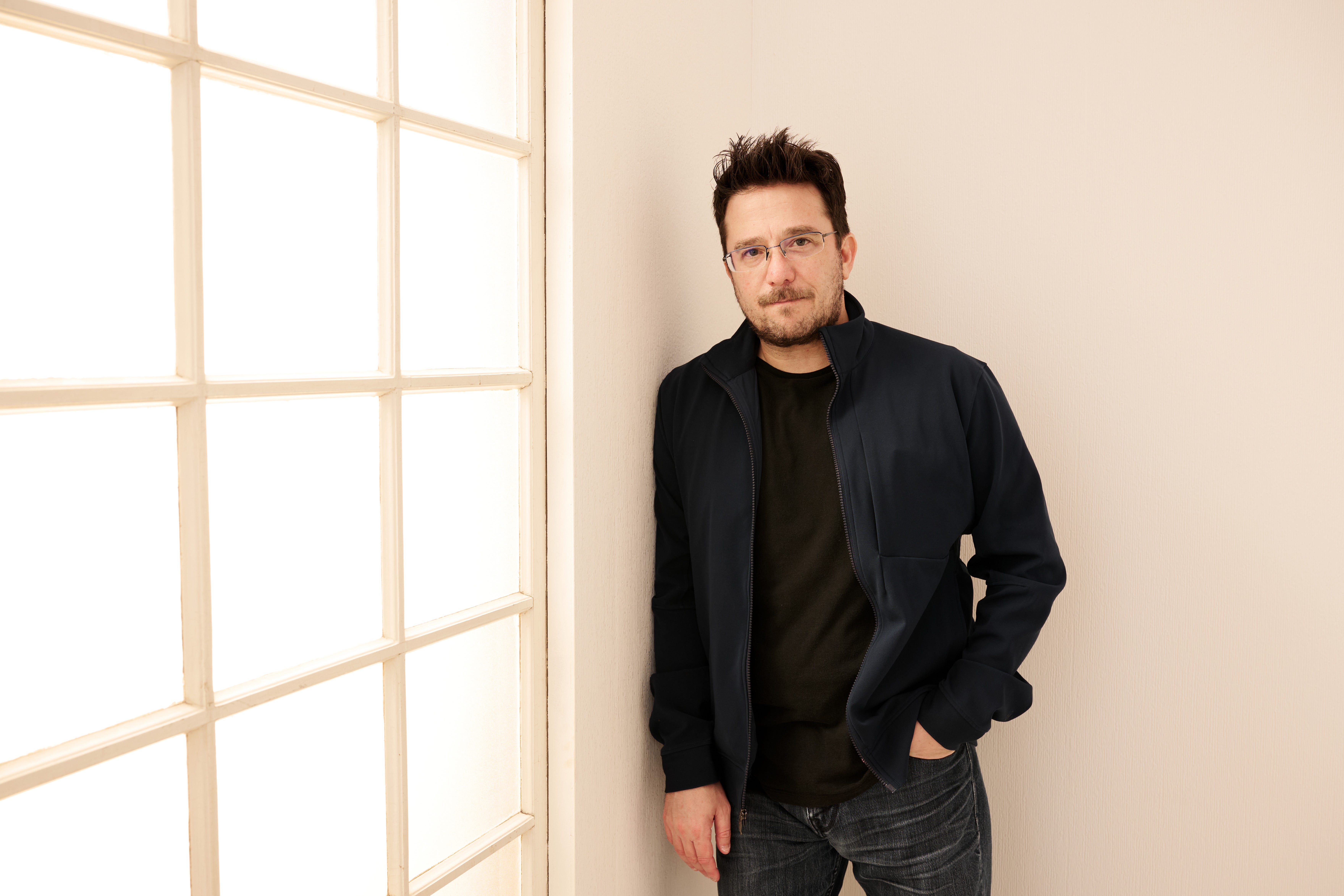 Billy Corben leaning on a wall