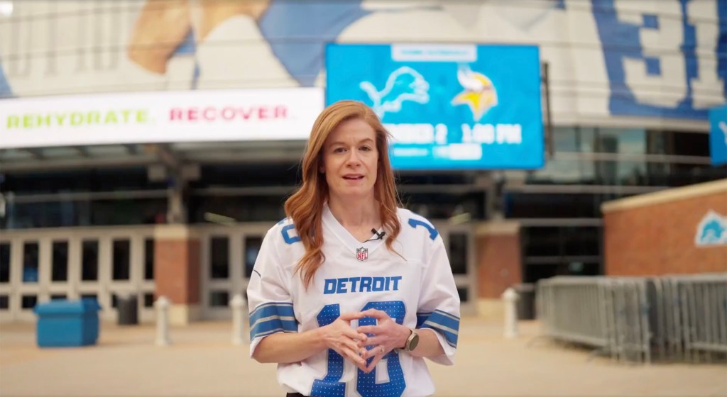 Mallory McMorrow in a Detroit Lions jersey outside a stadium.