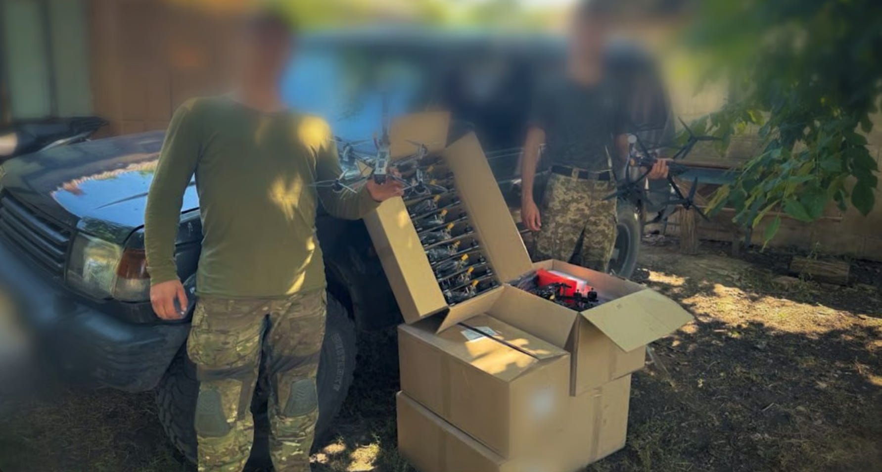 Soldiers with blurred faces hold up FPV drones received from Sternenko's foundation.