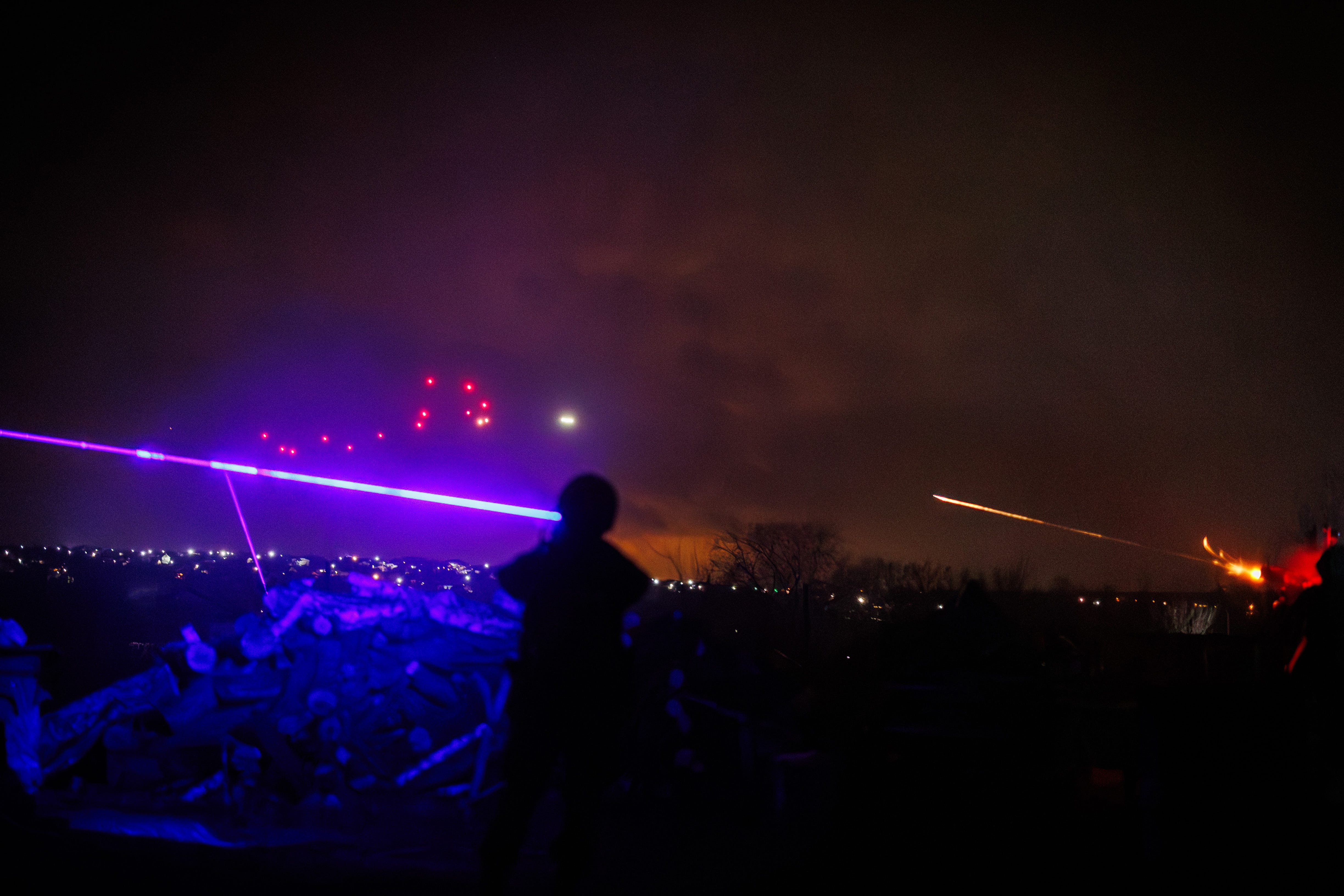 Ukrainian machine gunners open fire into the night sky.