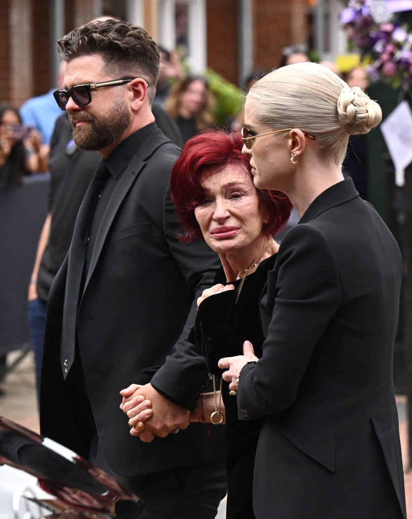 BIRMINGHAM, ENGLAND - JULY 30: (L-R) Jack Osbourne, Sharon Osbourne and Kelly Osbourne view tributes to the late Ozzy Osbourne from fans as his funeral cortege travels through his home city of Birmingham on July 30, 2025 in Birmingham, England. The Black Sabbath frontman passed away on July 22nd at the age of 76. His death occurred just a little over two weeks after his final live performance at the 'Back to the Beginning' concert in his hometown of Birmingham. (Photo by Leon Neal/Getty Images)