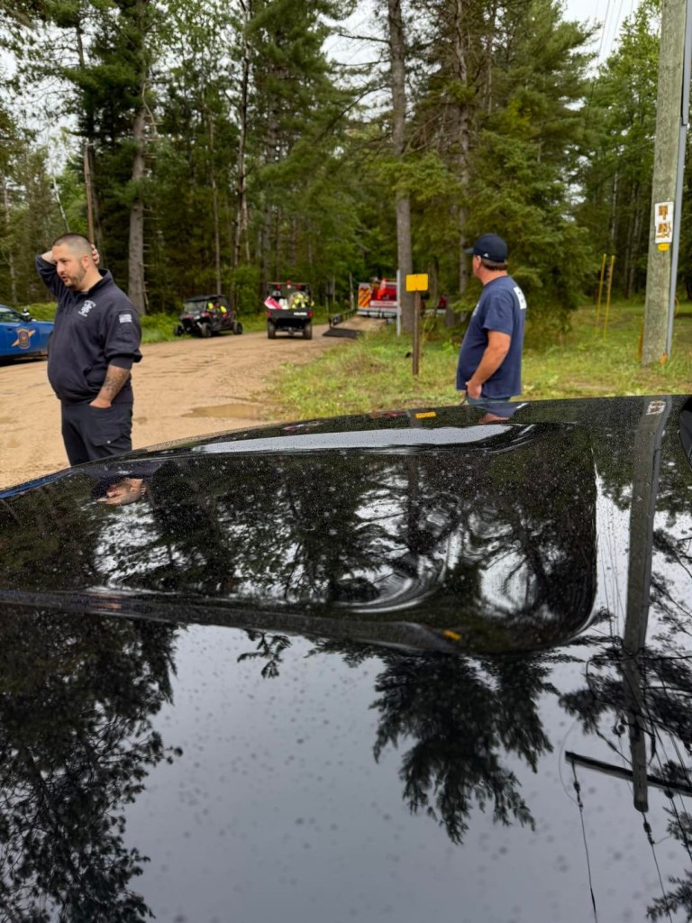 Rescued YouTube survival challenge contestant with emergency personnel.