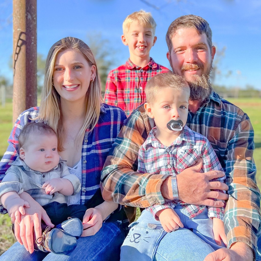 Family photo of a father, mother, baby, toddler, and older child.
