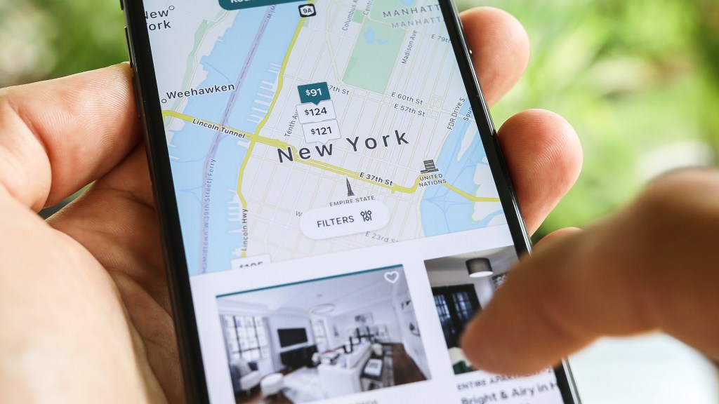 A phone screen shows the Airbnb app in New York, where the city’s 2023 crackdown has left only about 3,000 legal short-term rentals.