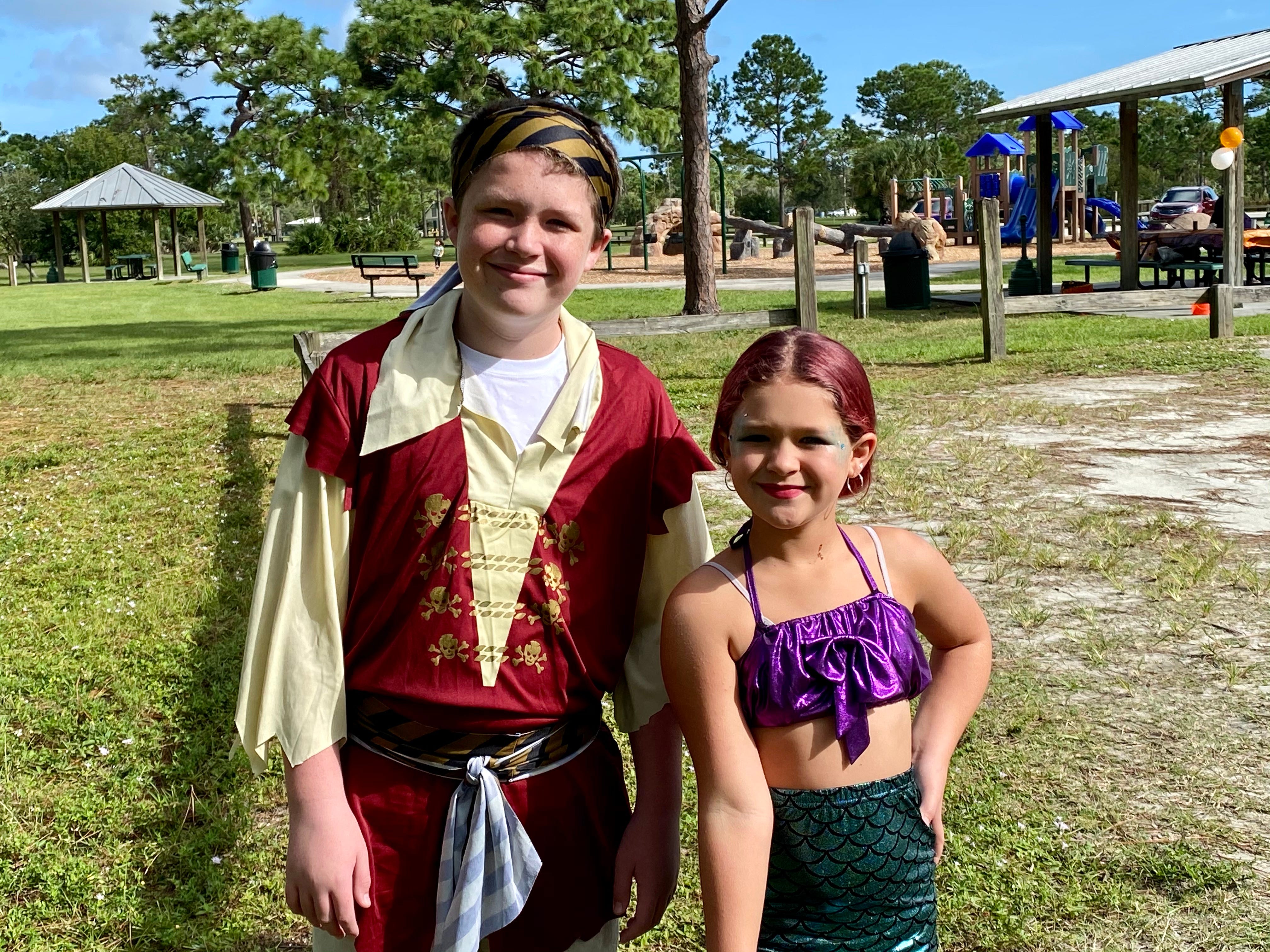 The author's kids on Halloween wearing costumes. Her son is wearing a pirate costume, and her daughter is dressed as a mermaid.