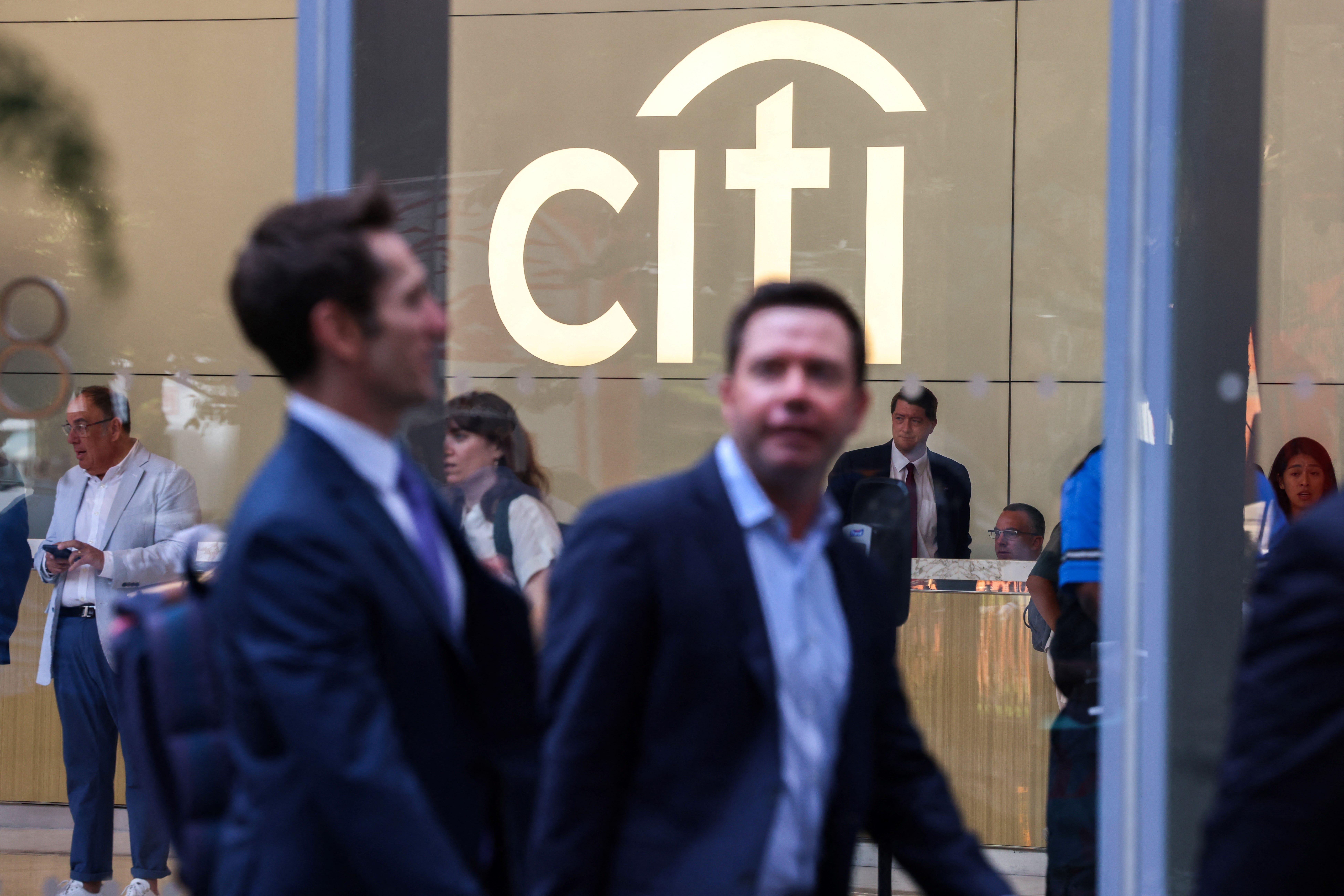 Two men in suits walk past Citi's HQ