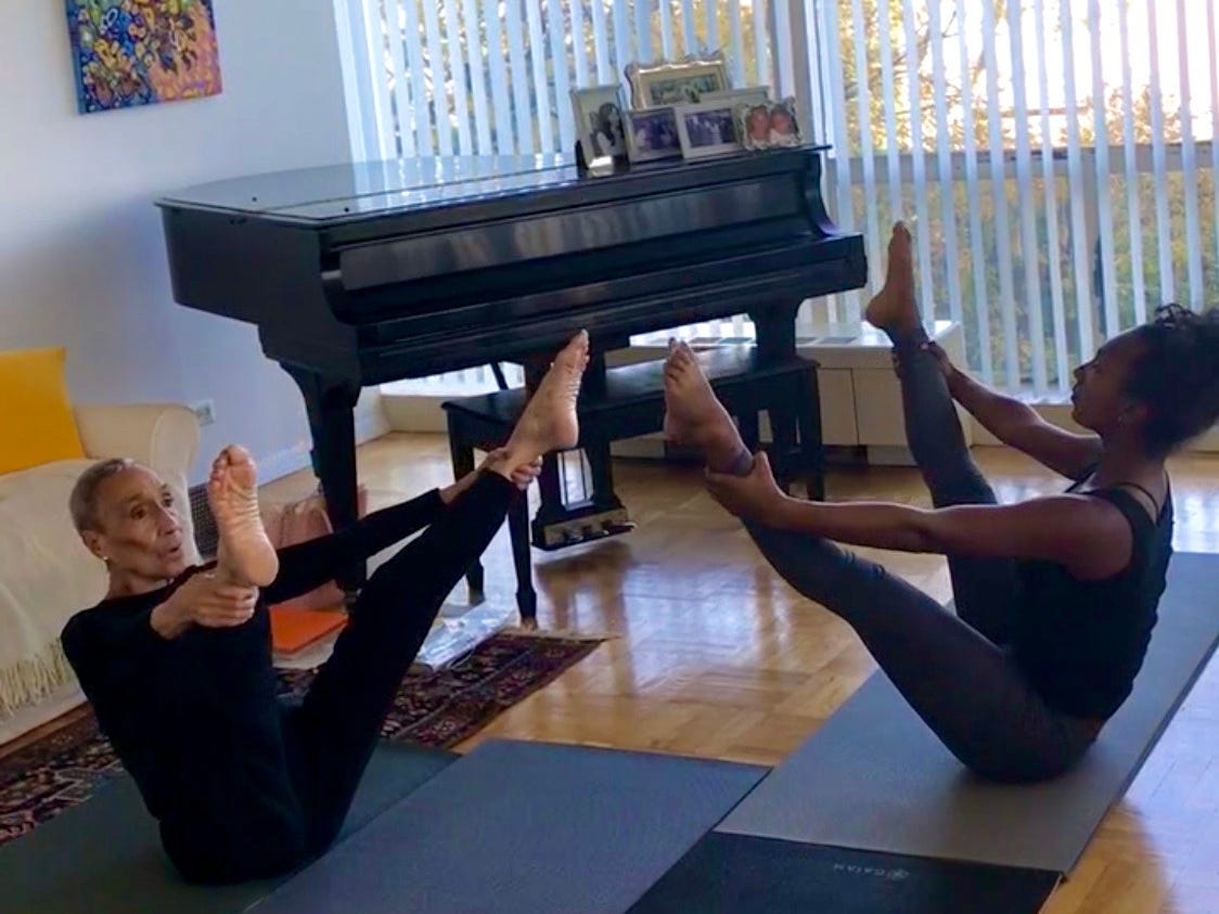 Aliya and Millie stretching in Millie's living room.