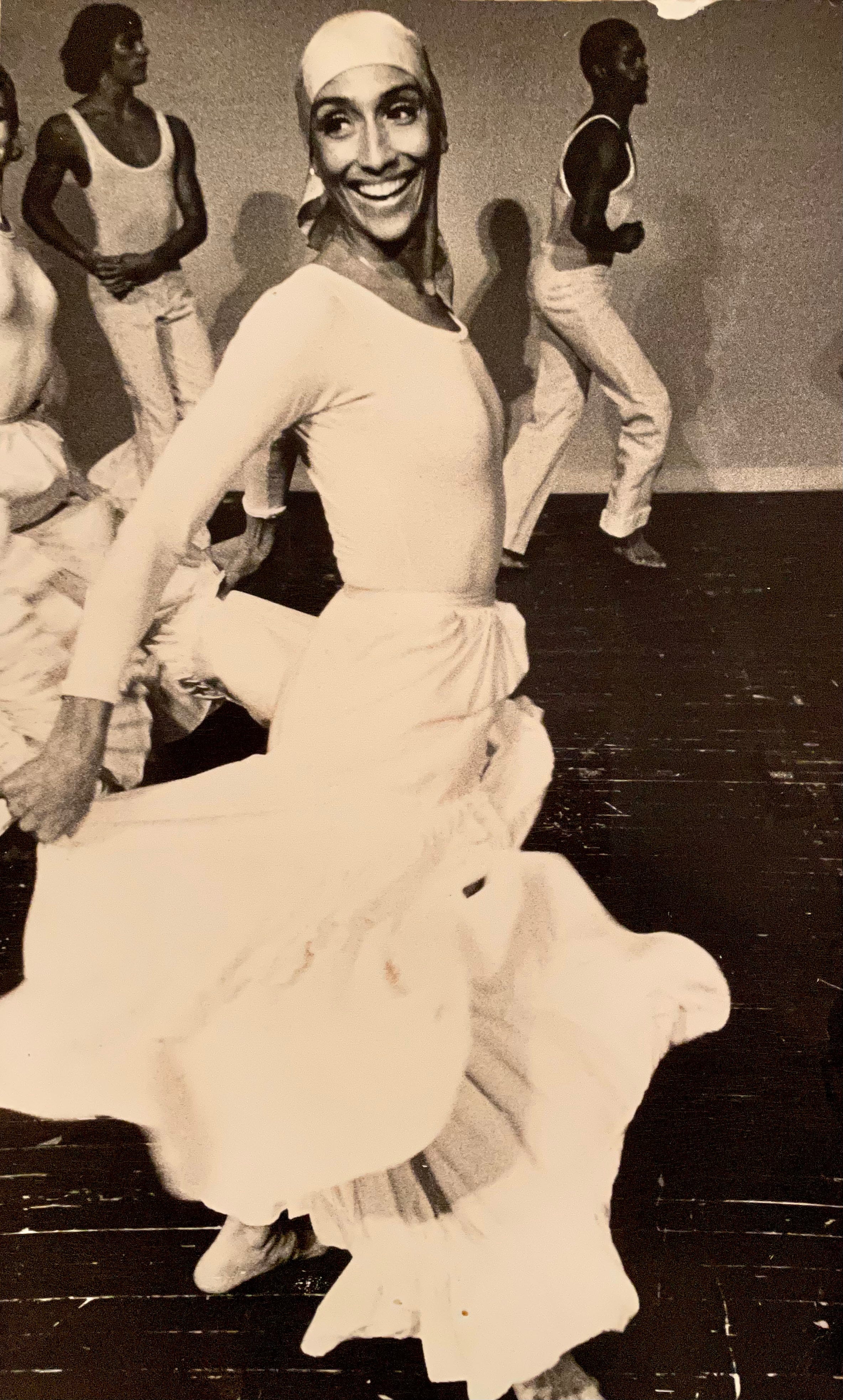 Millie in her 40s dancing in a white dress.