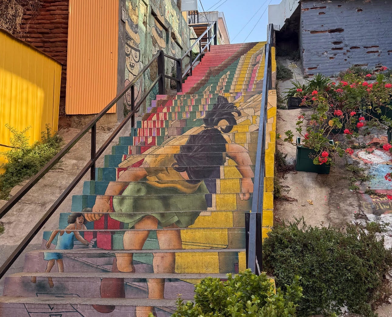 A mural of two girls painted on a large set of stairs.